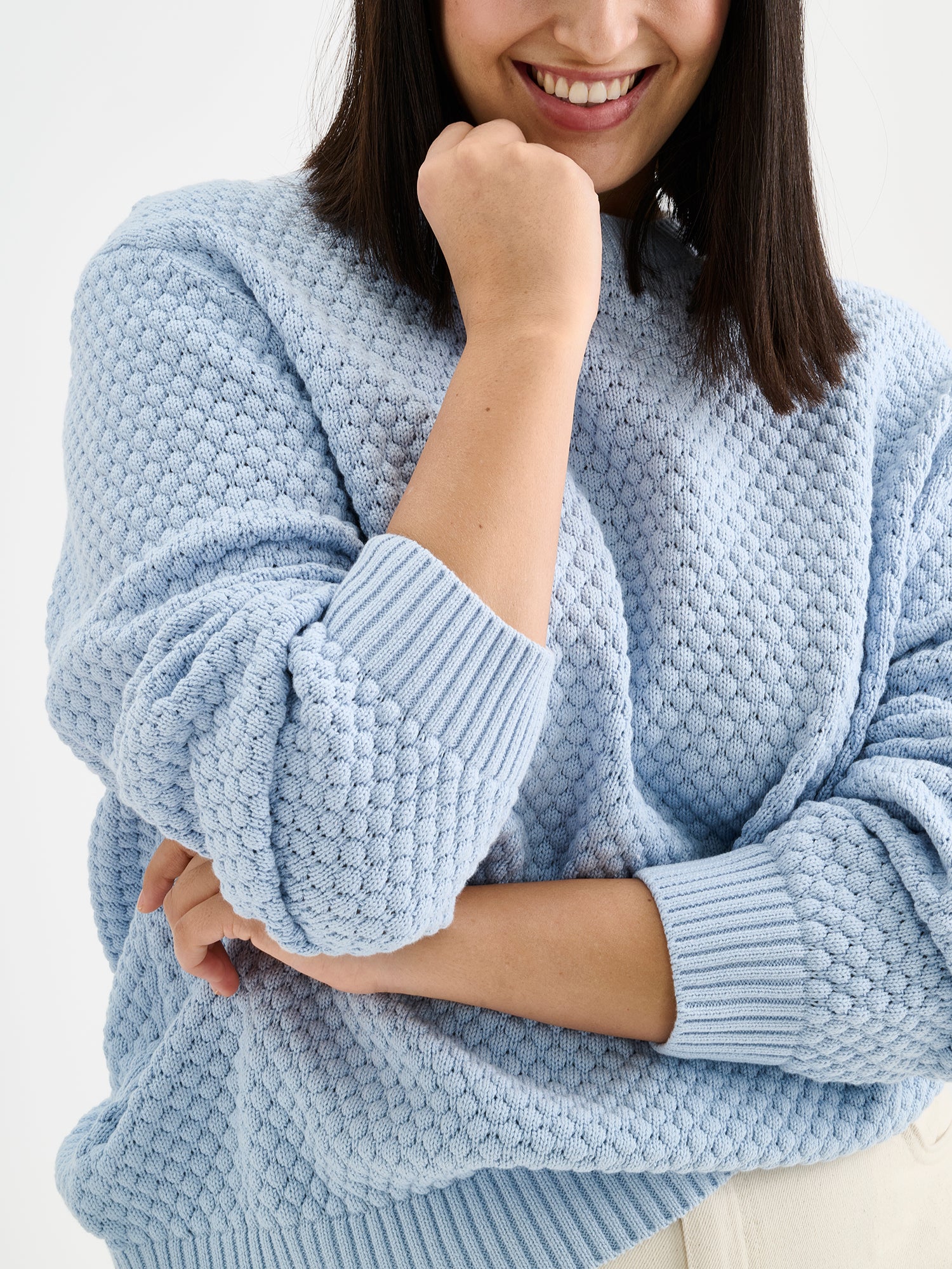 Women's KUMPU Knit Sweater in light blue on a model, close-up
