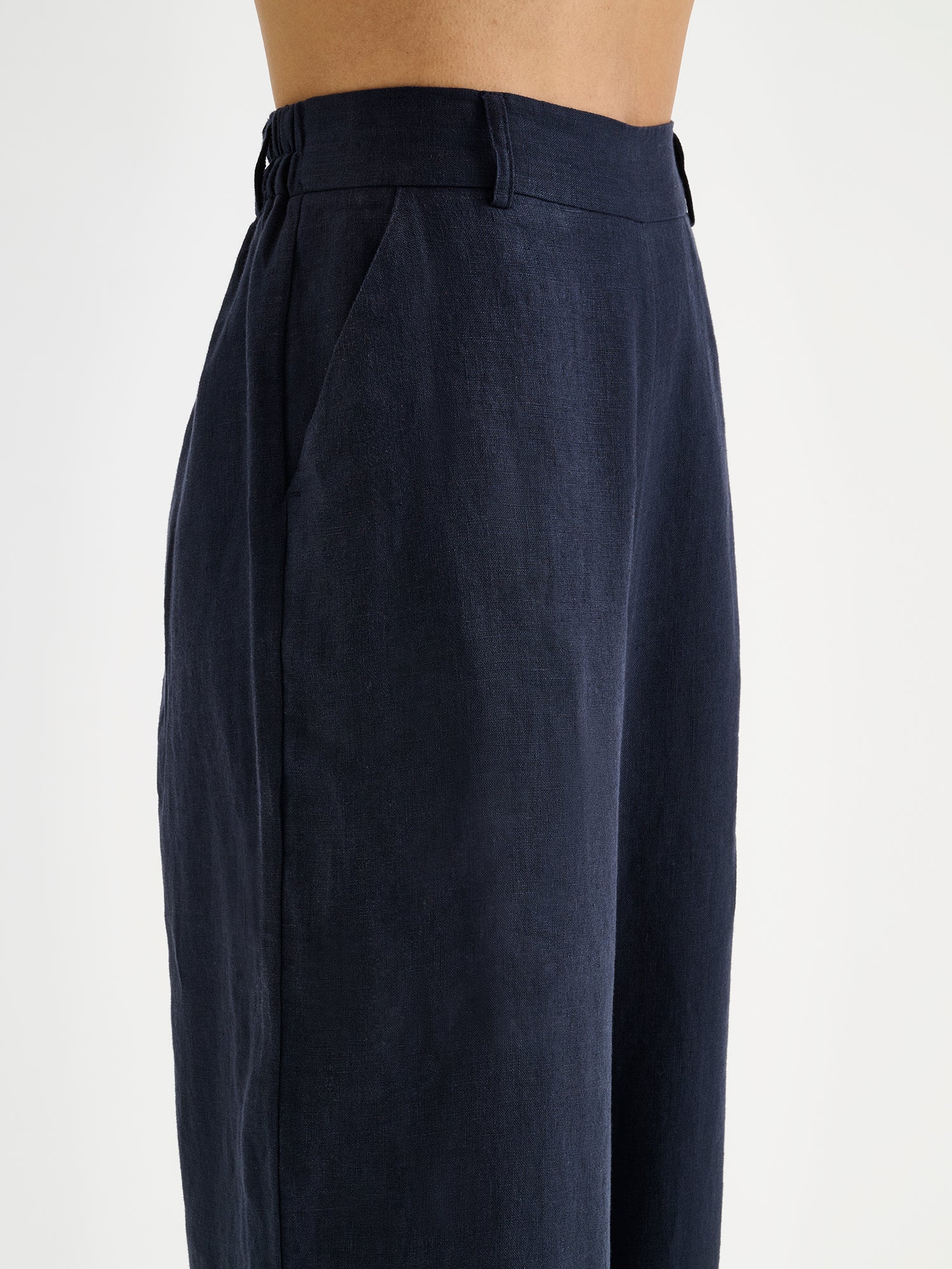 SAARI linen pants in a chic dark blue color on a model, close-up.