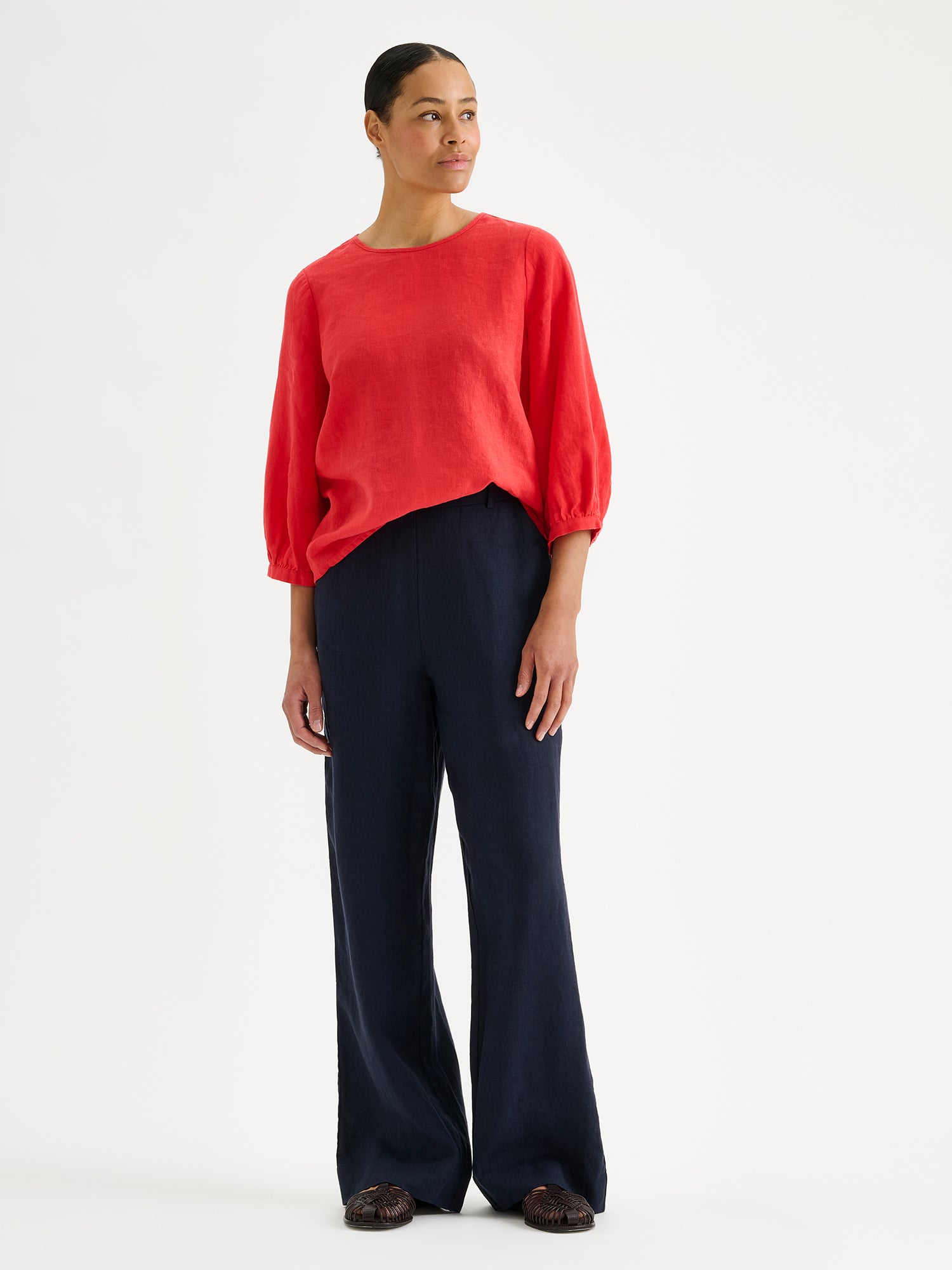 SAARI linen pants in a chic dark blue color on a model with a red linen blouse.