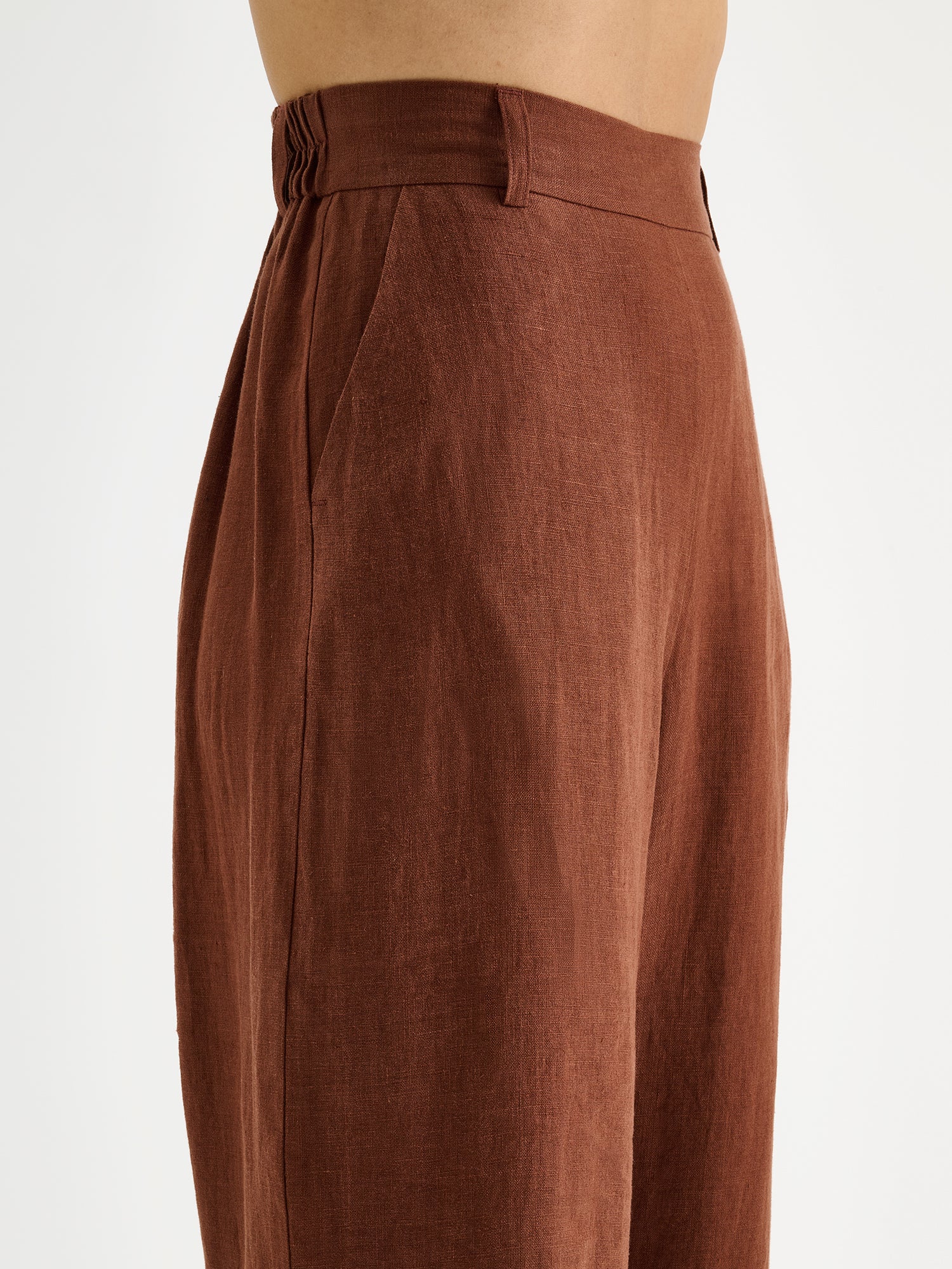 SAARI linen pants in a chic brown color on a model, close-up.