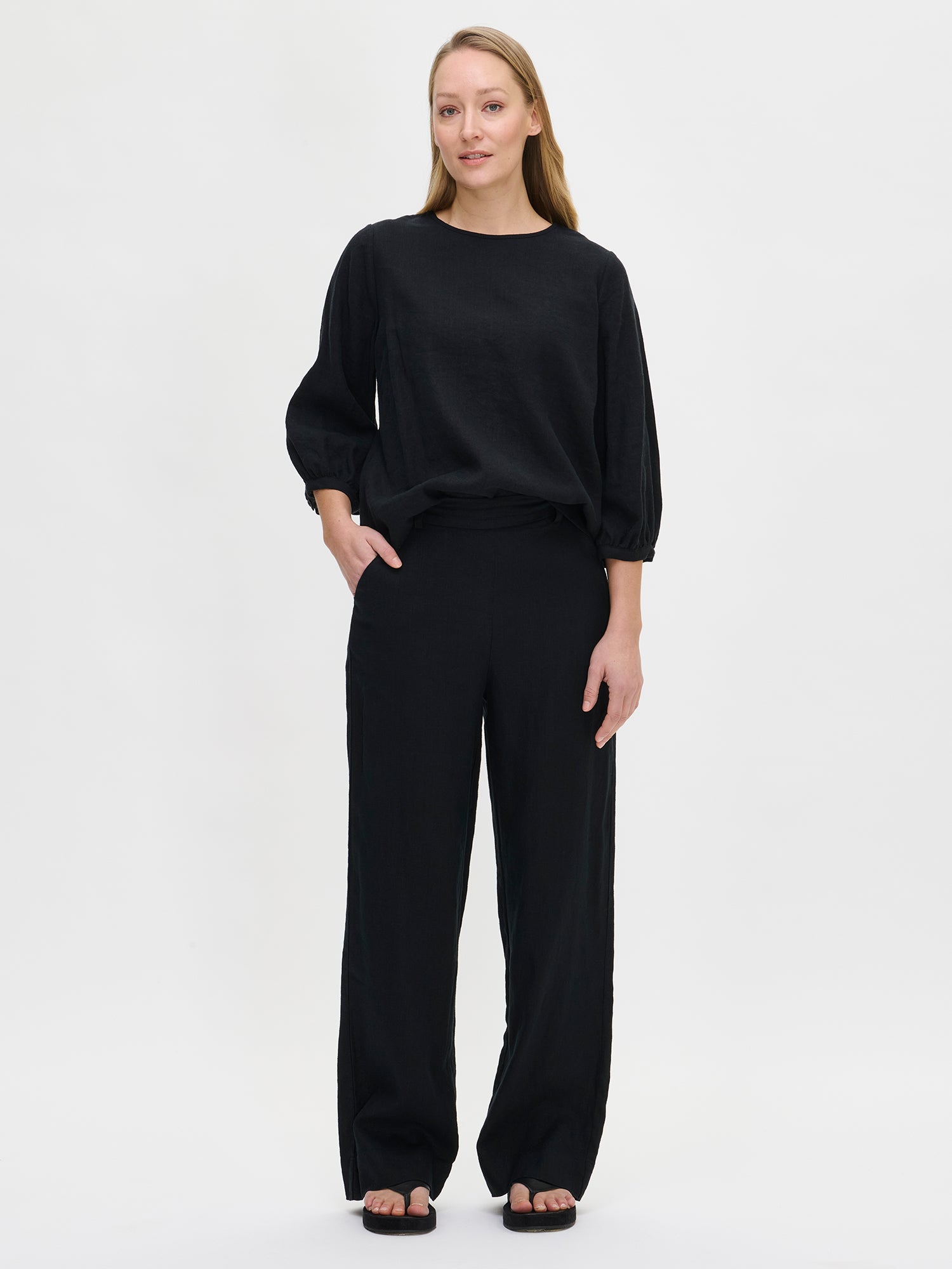Expertly crafted from premium linen fabric, these classic black SAARI linen trousers provide effortless elegance for both everyday wear and special occasions. Worn by a model in size 36.