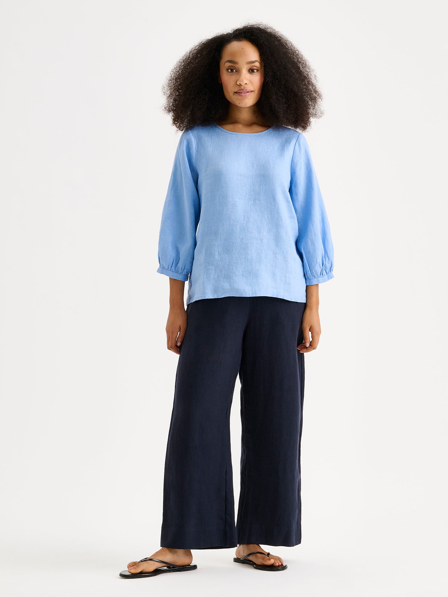 Nanso SAARI linen culottes with elasticated waist and side pockets in a sophisticated dark blue shade on a model with light blue linen blouse.