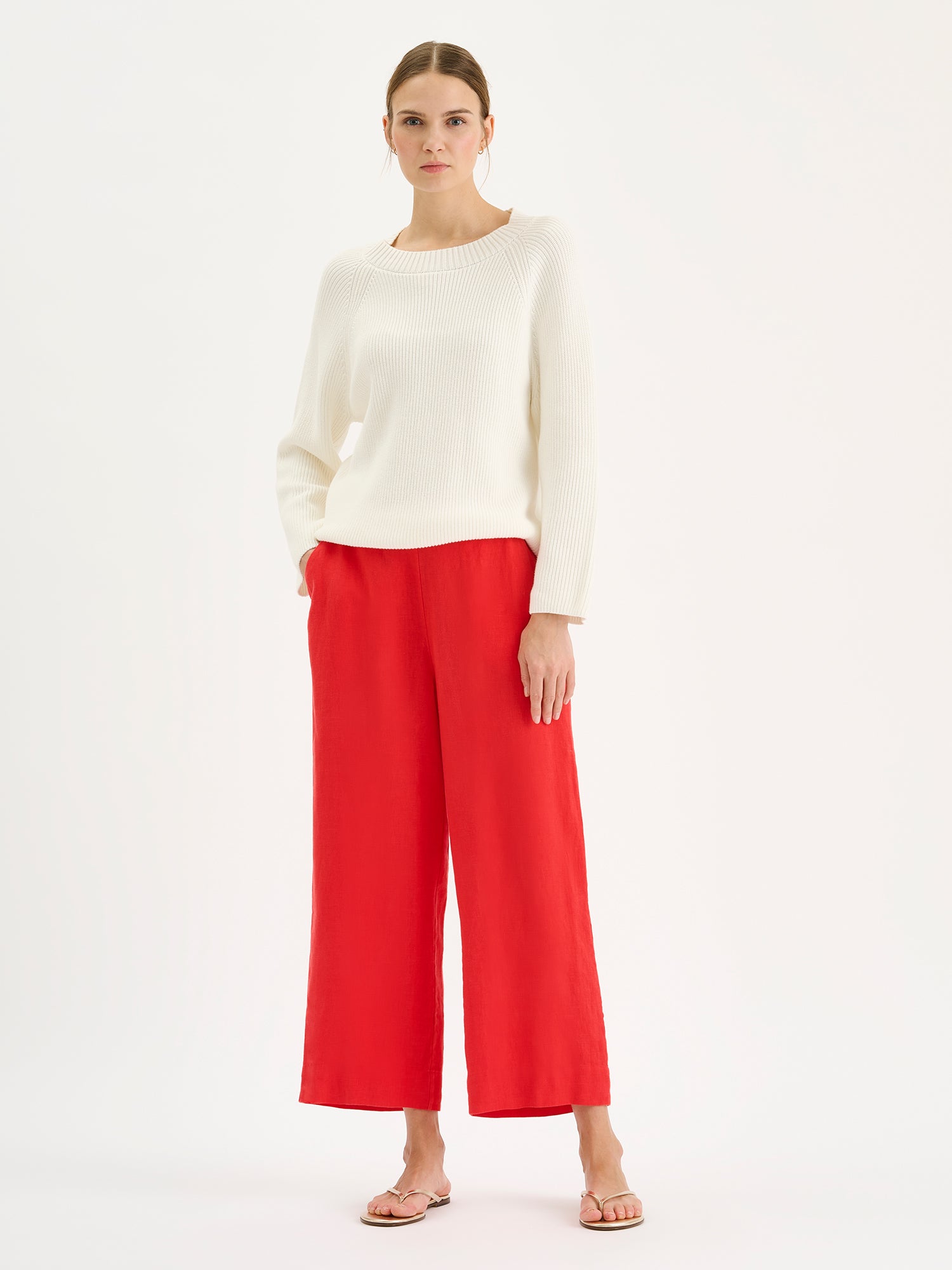 Nanso SAARI linen culottes with elasticated waist and side pockets in a sophisticated red shade on a model with a white knit sweater.