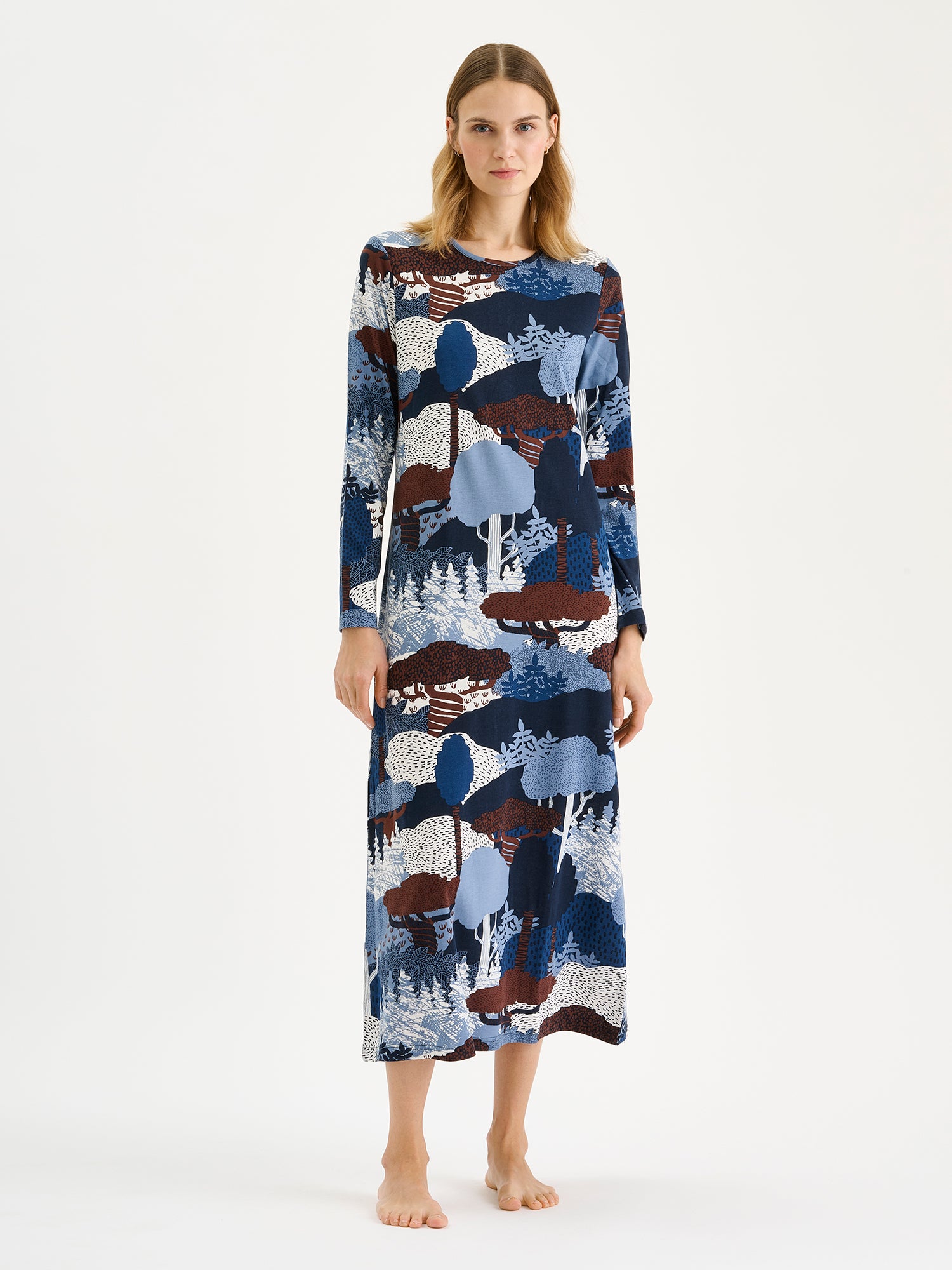 Nanso women's long Ruska nightgown features a beautiful nature-inspired print in harmonious shades of blue and brown. Pictured on a model.