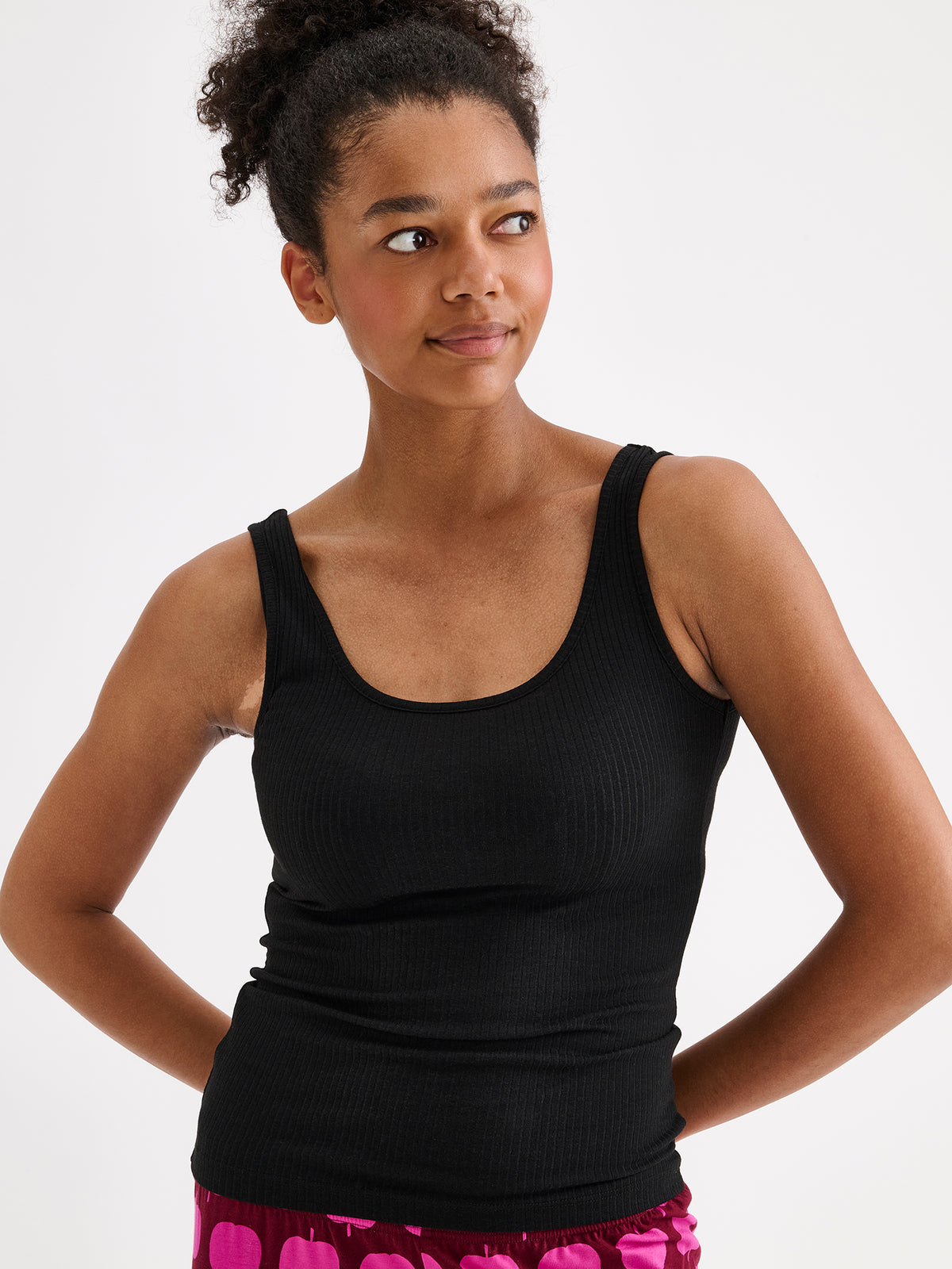 Nanso women's Heila ribbed top in black on a model with pink patterned pants close-up. | S - 177cm
