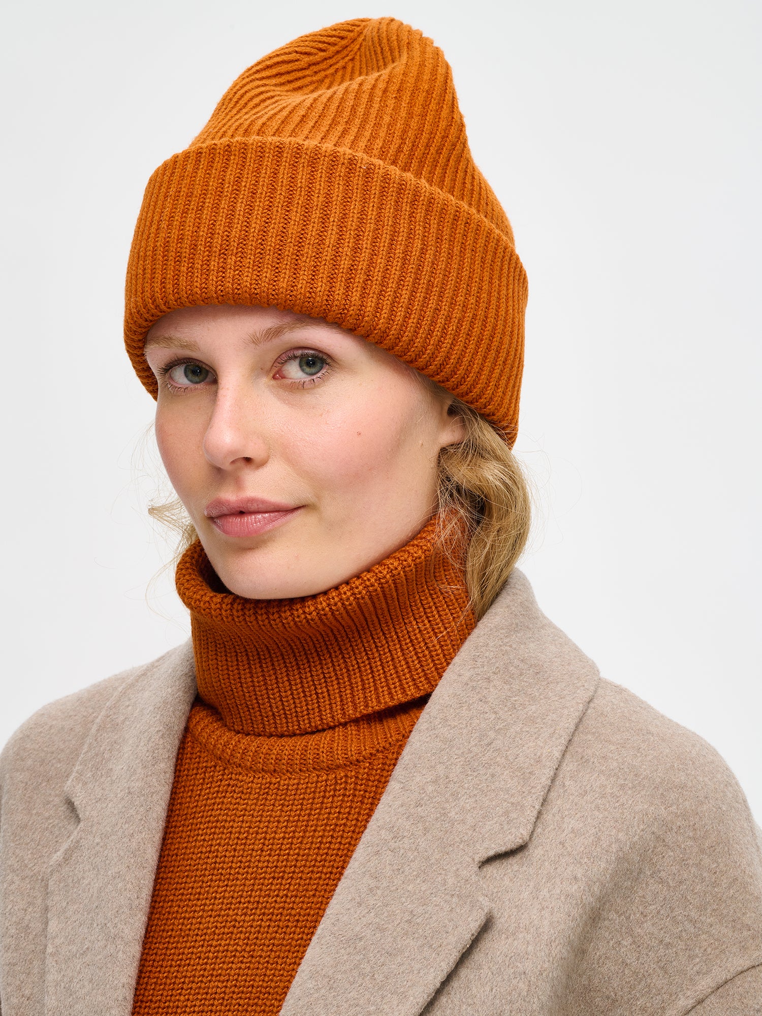 Women's brown Utu beanie features a patent knit. On a model
