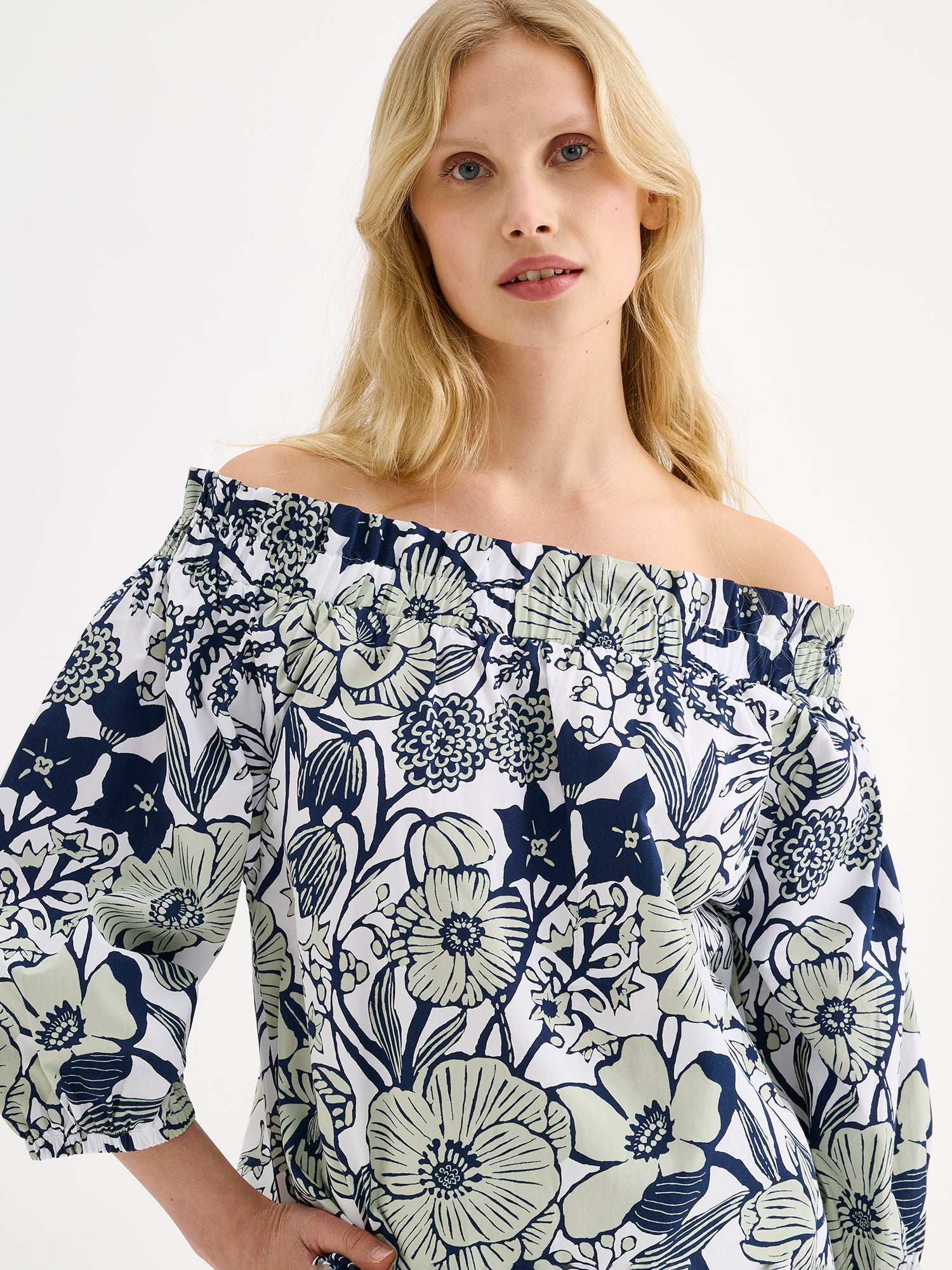 Nanso women's HUVILA Blouse with a charming floral print features a fresh, serene blue-green palette. pictured on a model, close-up.