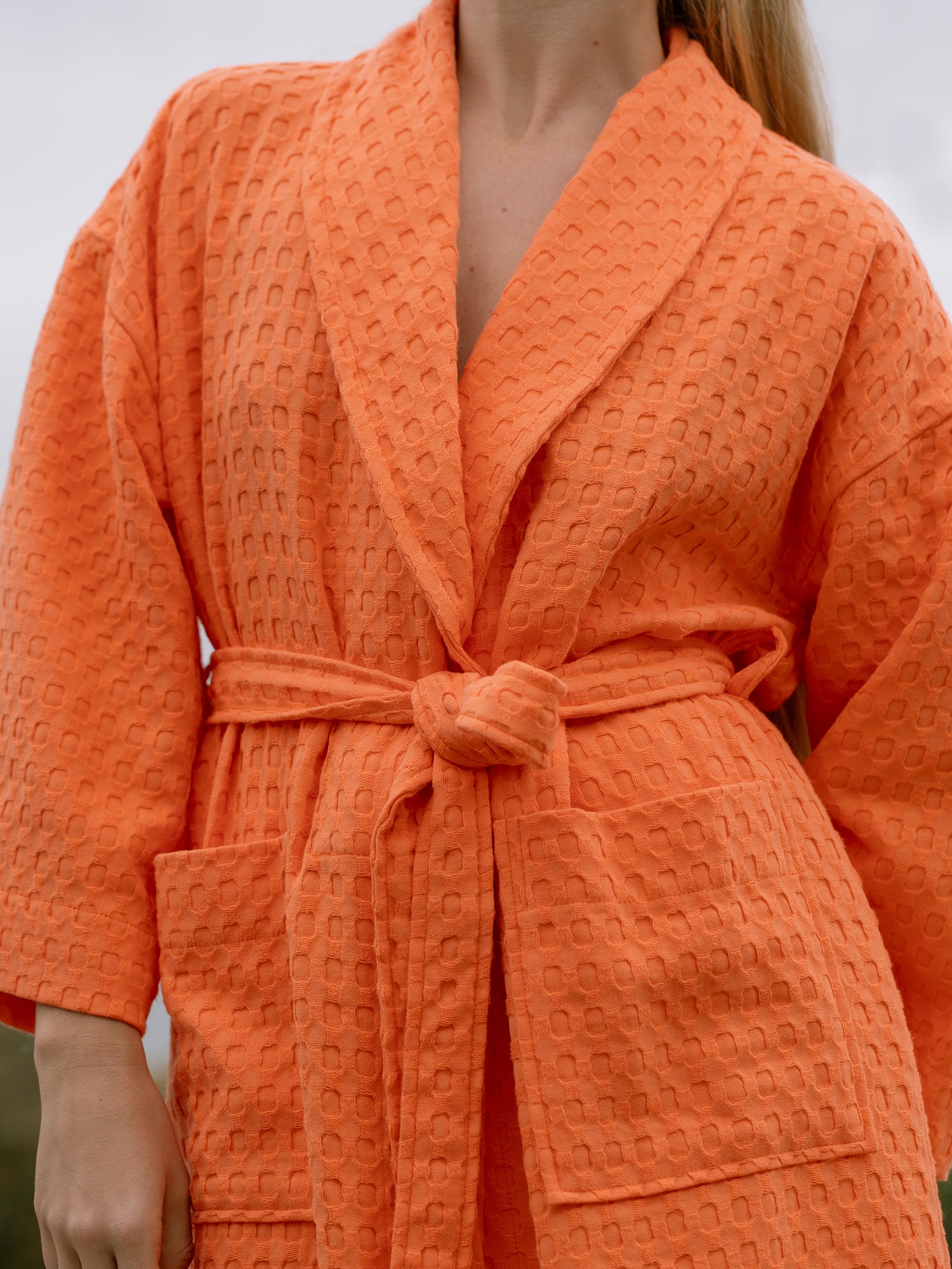Nanso women's soft cotton bathrobe in orange on model from front.