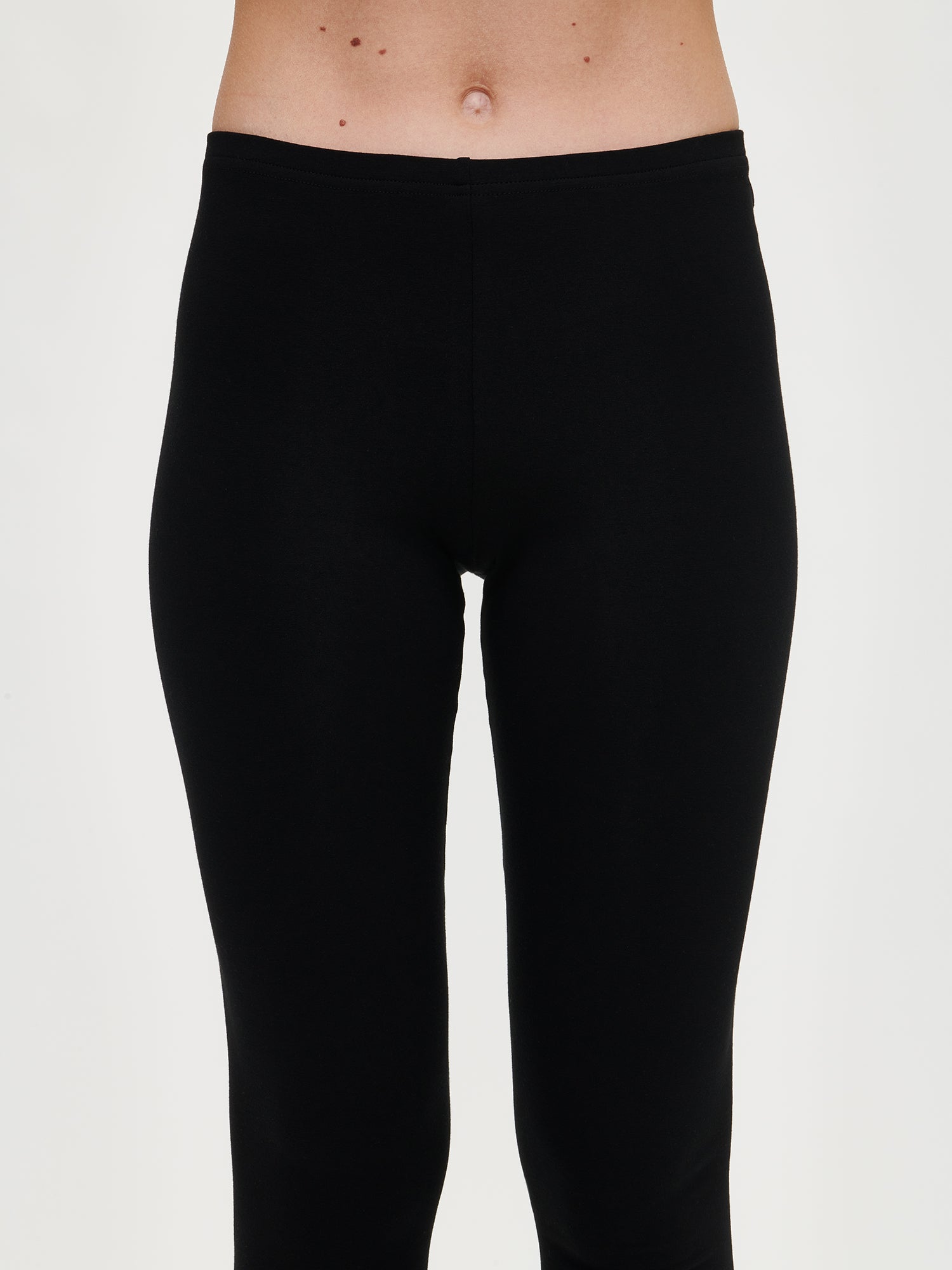 Nanso women's Basic Soft black leggings crafted from soft, brushed cotton-elastane blend that delivers warmth and comfort. On a model pictured from the front, close-up.