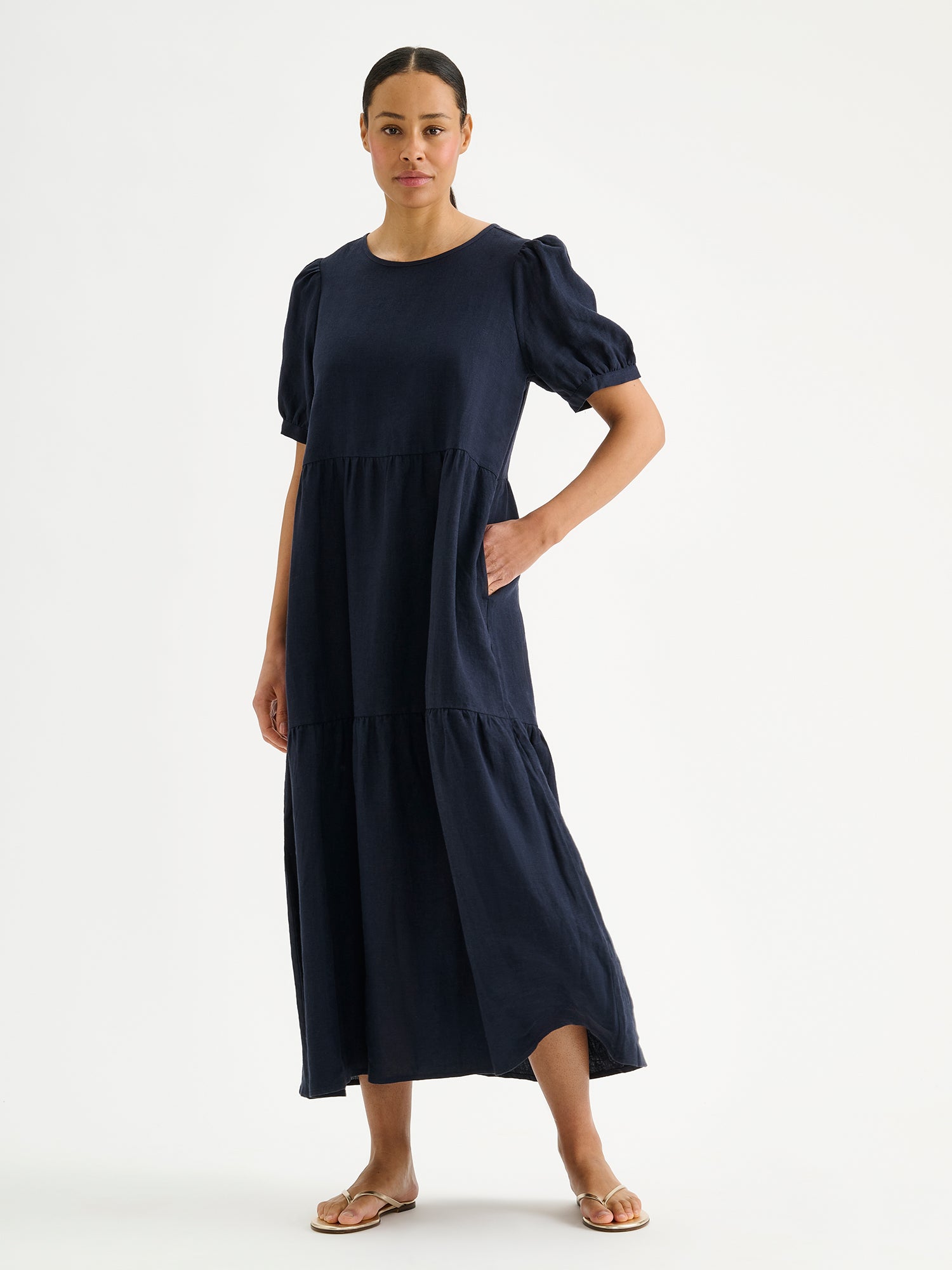 Nanso sarastus dark blue linen dress with voluminous frill layers and short puff sleeves on a model.
