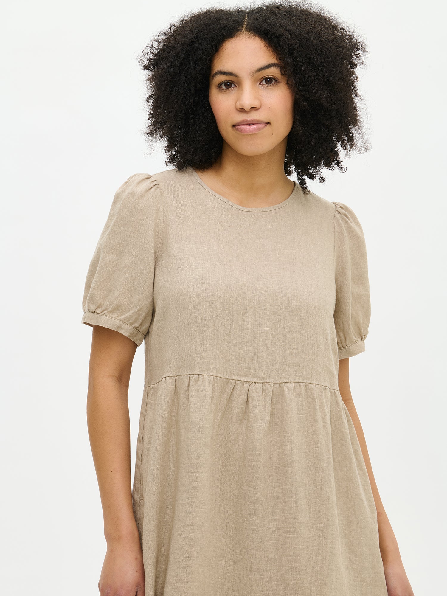 Nanso women's beautiful Sarastus maxi linen dress in beige features voluminous frill layers and short puffed sleeves from the front close up.