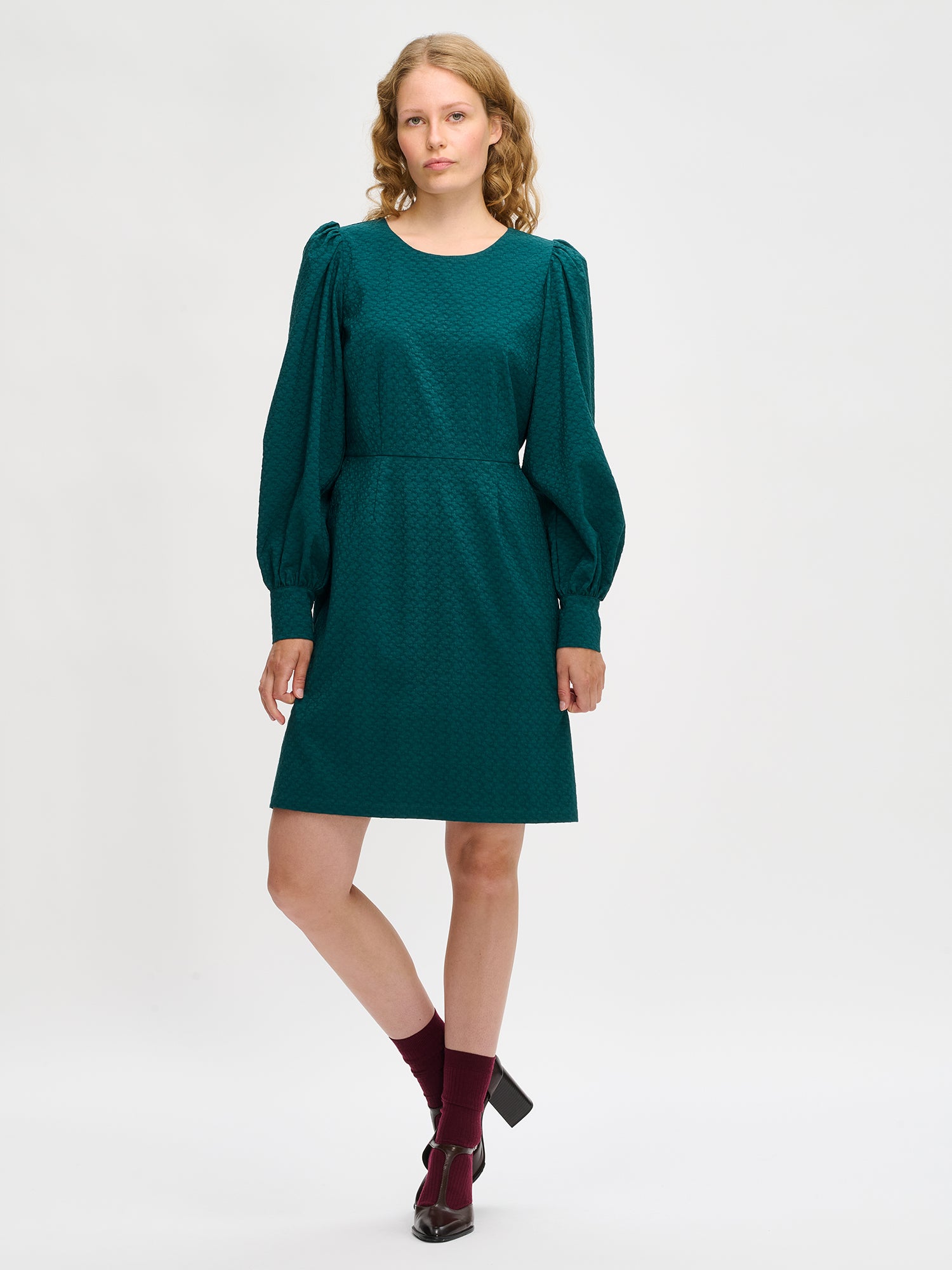 Nanso's elegant dark green Reliefi dress for women features a stylish design, on a model.