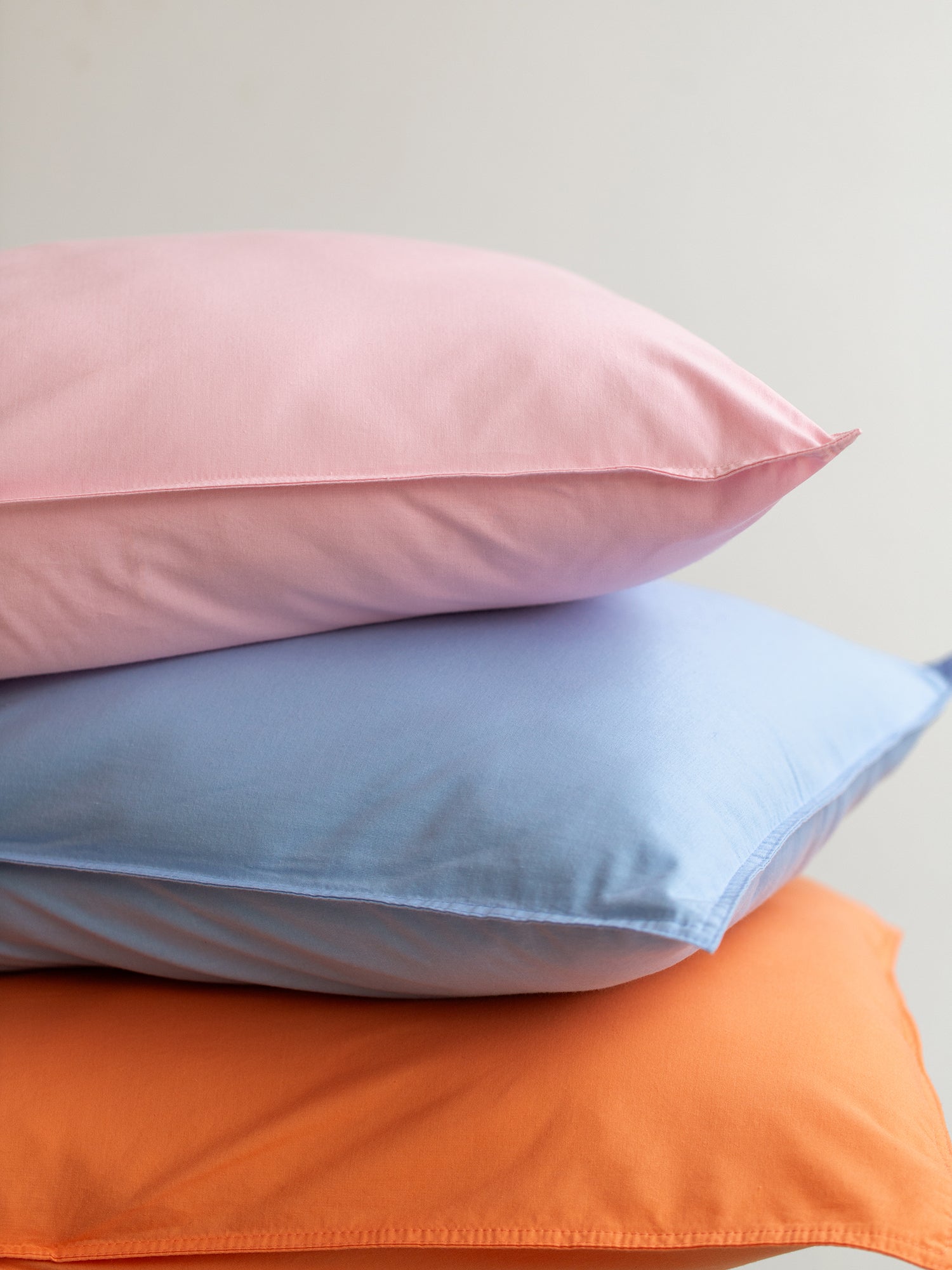 Nanso home's UNI duvet cover in orange pillow stack.