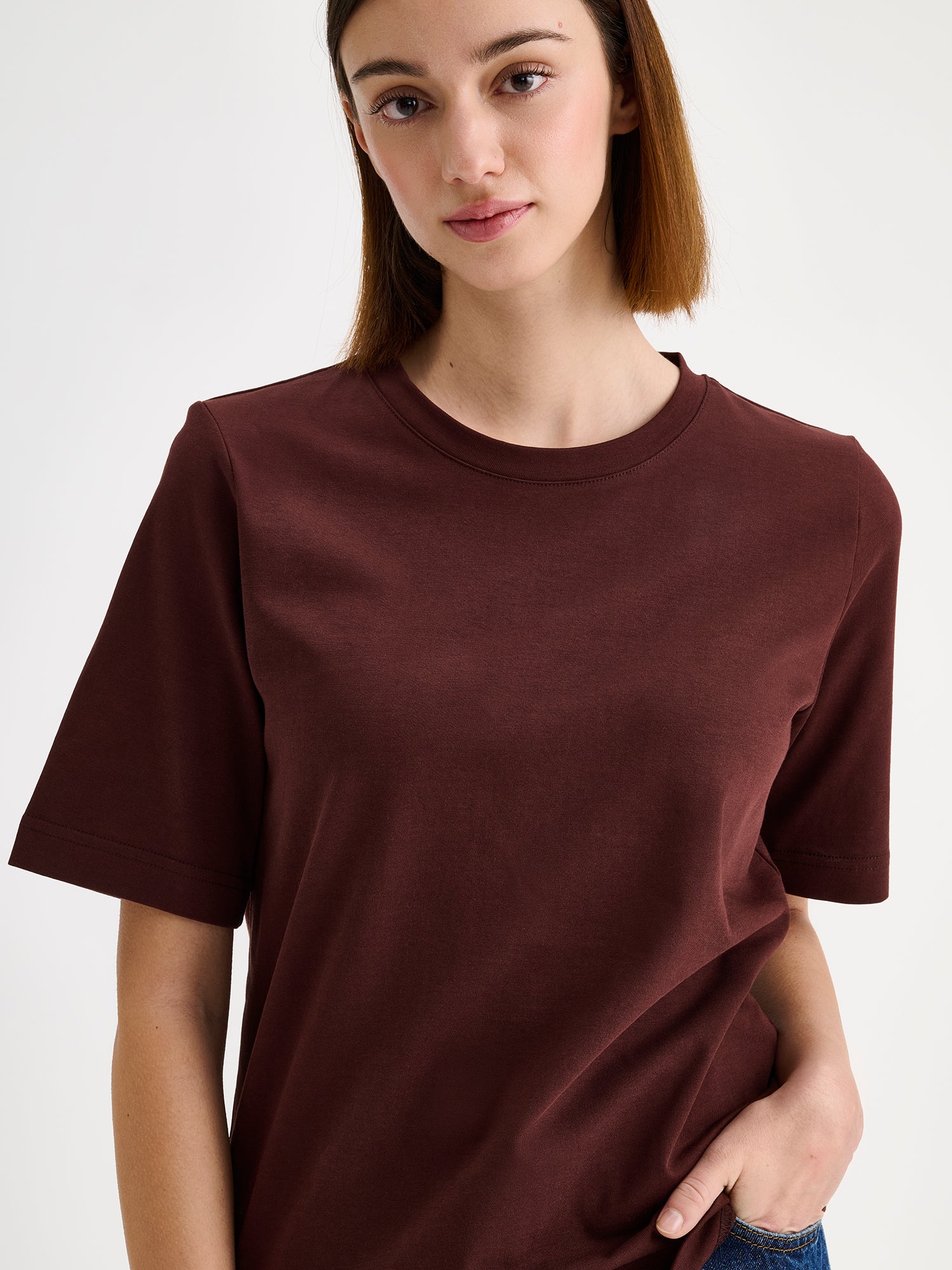 Women's Normi T-shirt in Dark Brown with relaxed fit and straightforward silhouette, on a model, close-up.