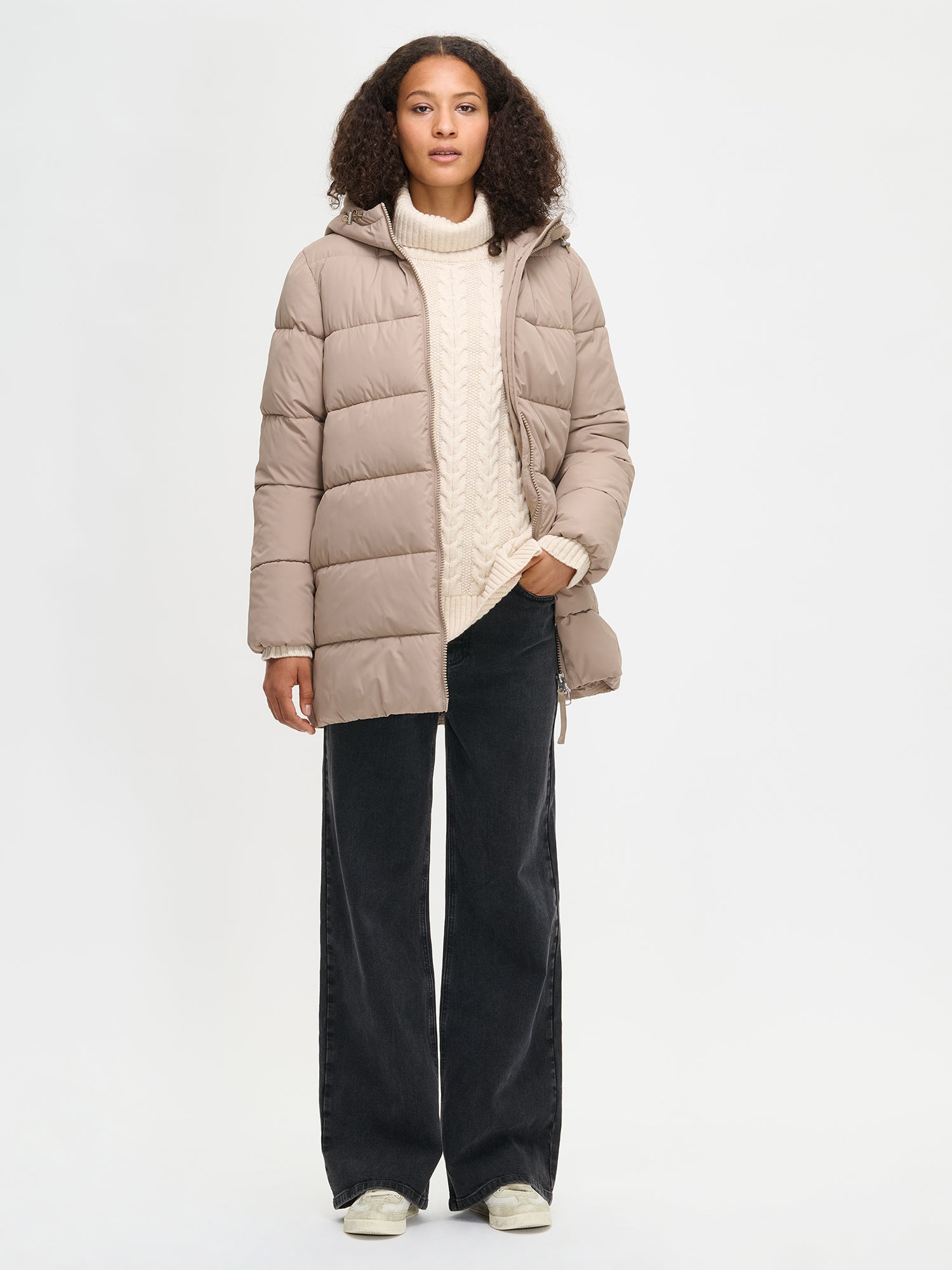 The beige Lumi padded coat provides warmth with its soft, lightweight padding and generous fit. worn by a model in size S and jacket open.