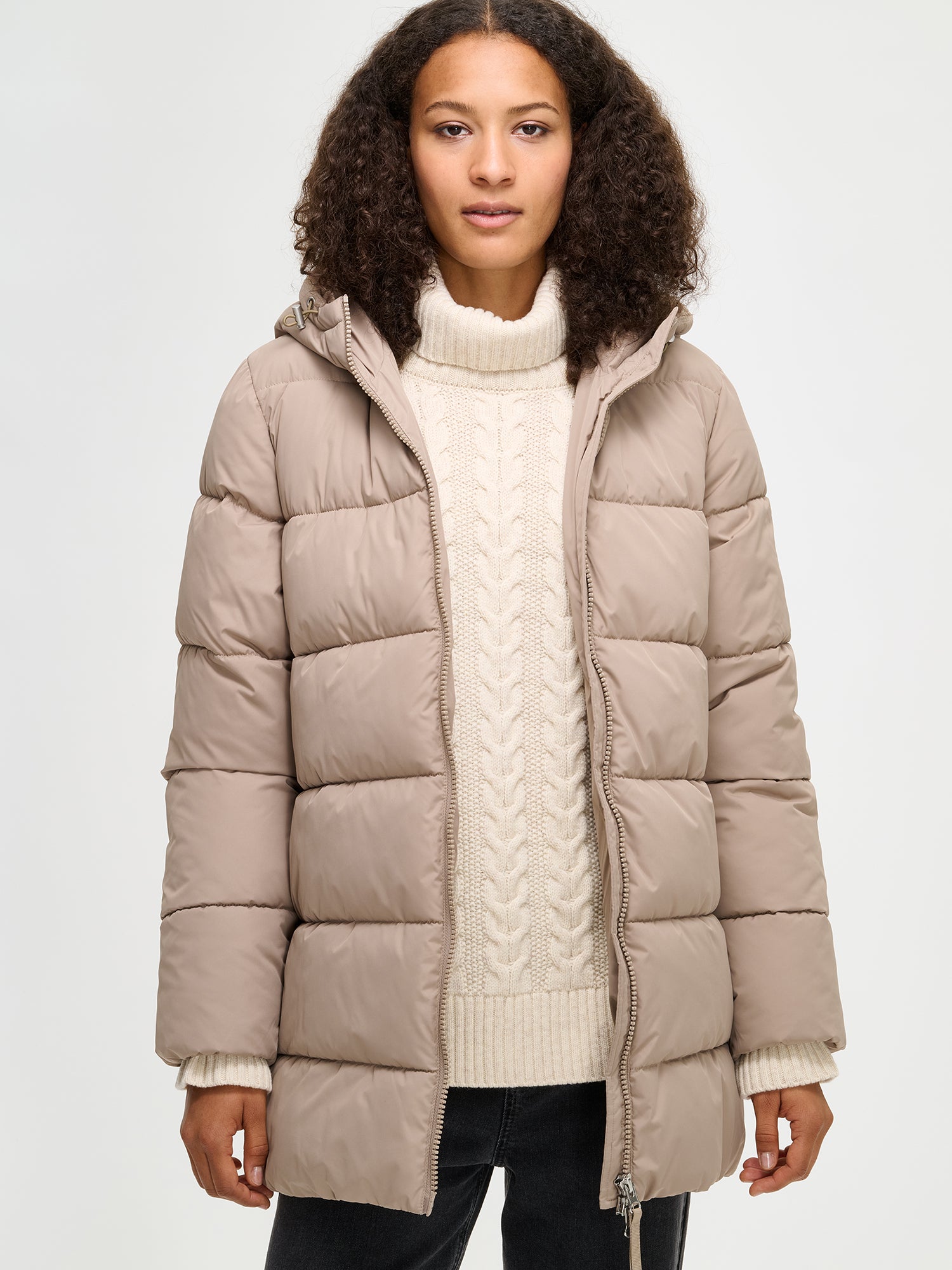 The beige Lumi padded coat provides warmth with its soft, lightweight padding and generous fit. From the front.