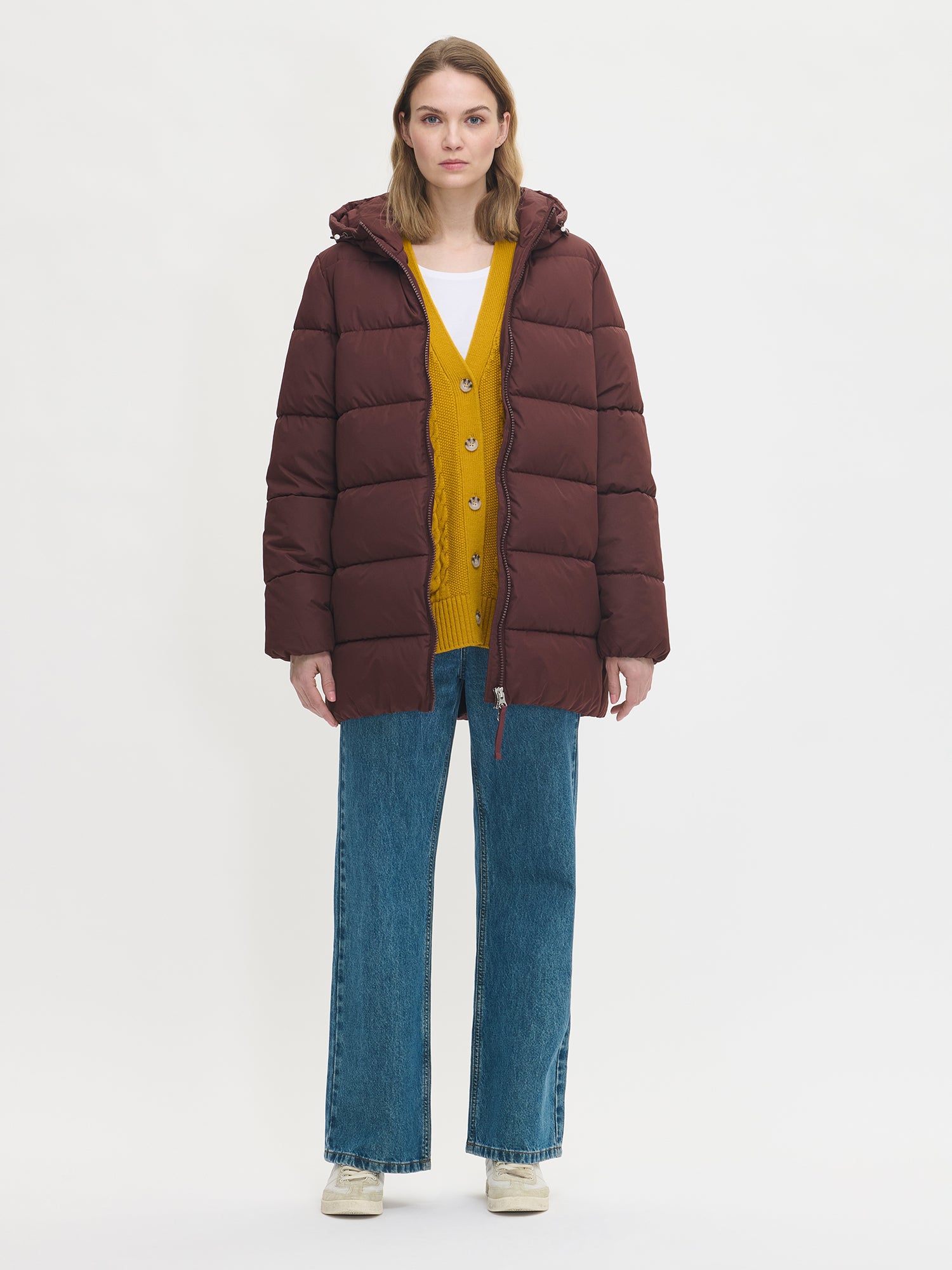 The dark brown Lumi padded coat provides warmth with its soft, lightweight padding and generous fit. Worn by a model in size S and jacket open.