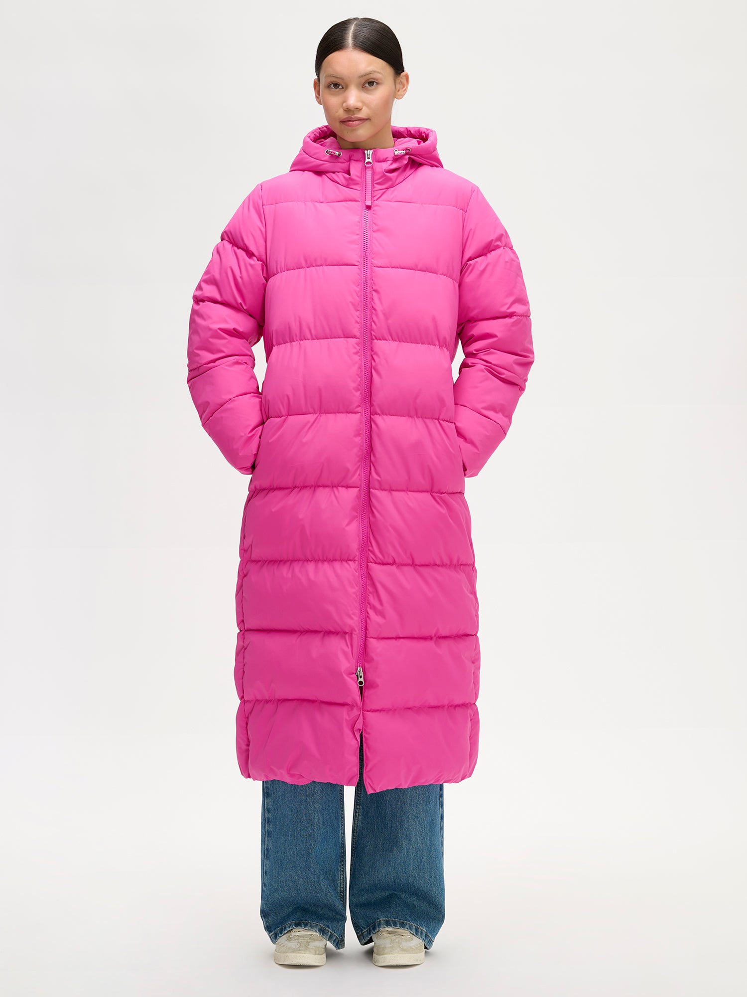 Nanso women´s Lumi Long Pink Puffer Coat in pink offers cozy warmth with its lightweight, puffy insulation. Worn by a model in size S.