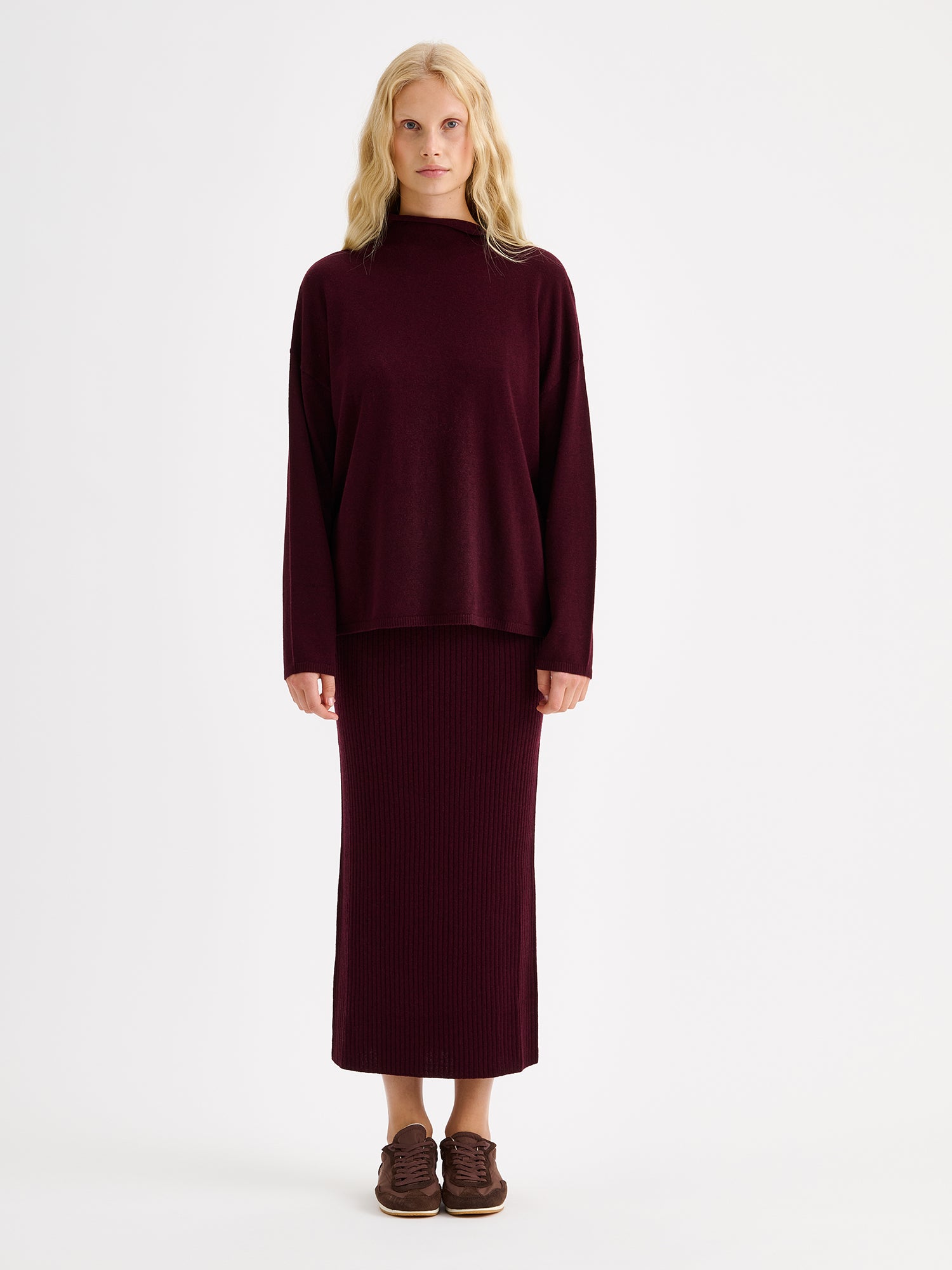 Nanso women´s burgundy Villis long-sleeved sweater on a model with a matching skirt