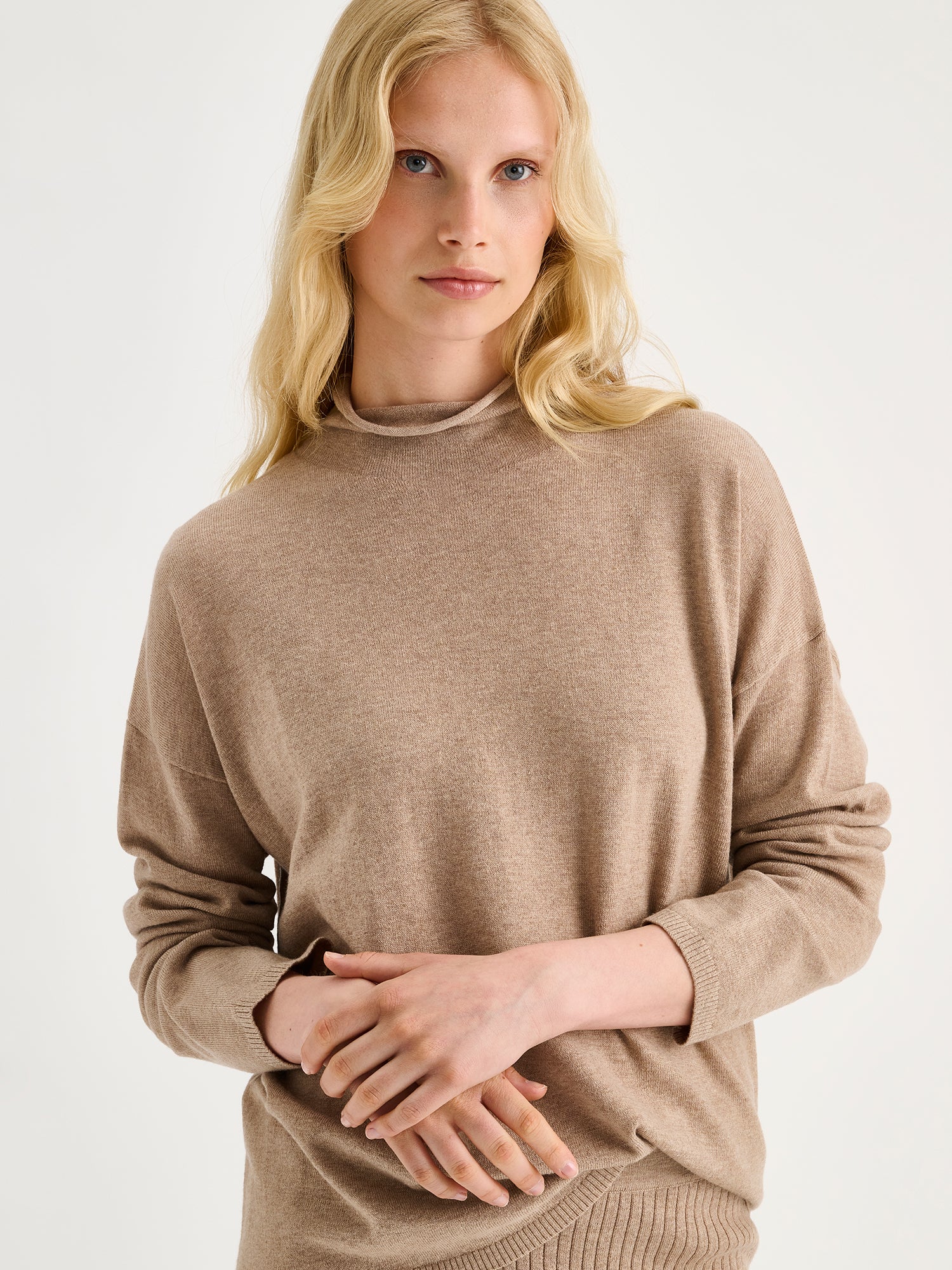 Nanso women´s beige Villis long-sleeved sweater on a model with matching skirt, close-up