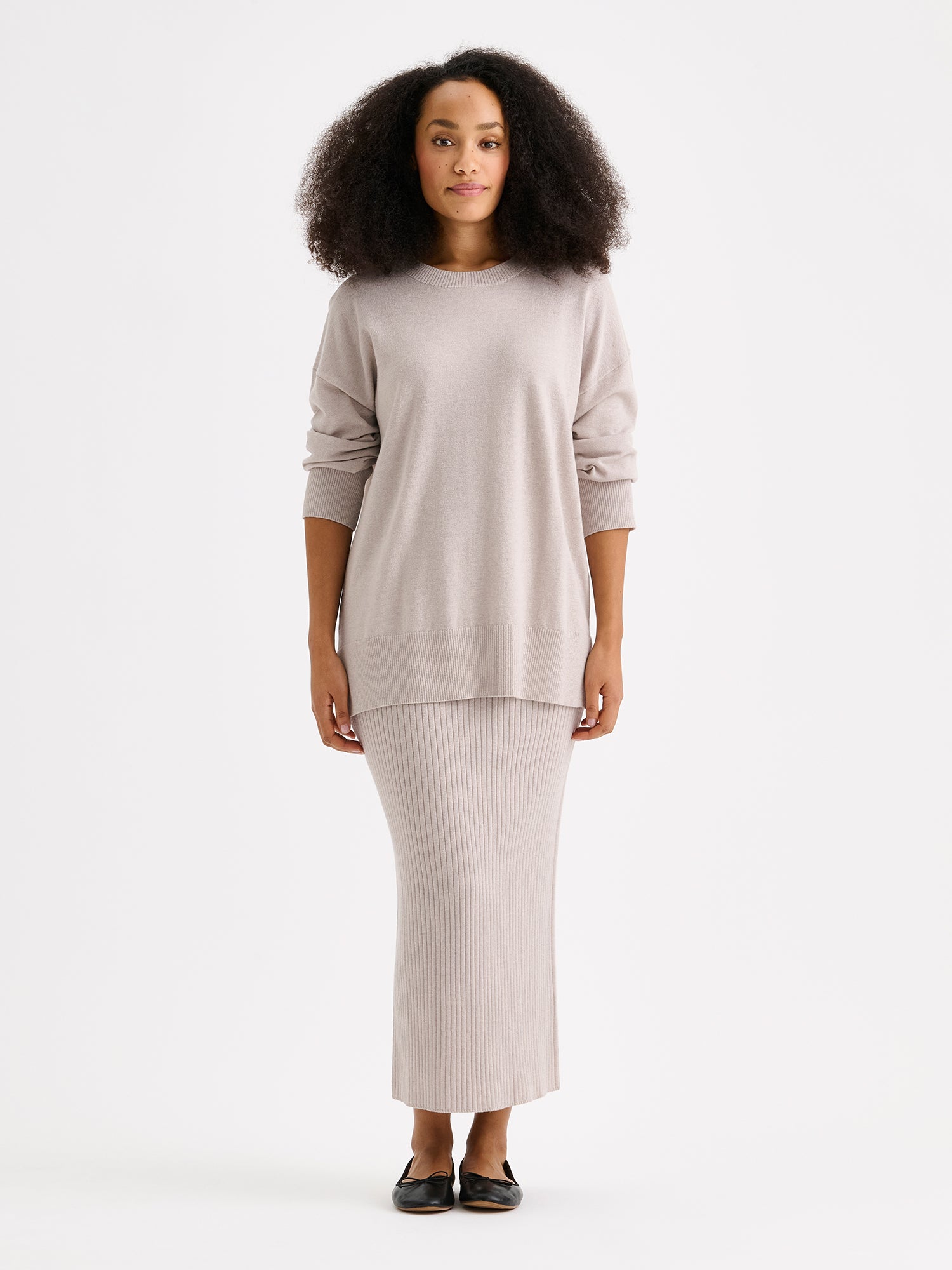 Villis ribbed knit skirt and sweater on a model in greige.