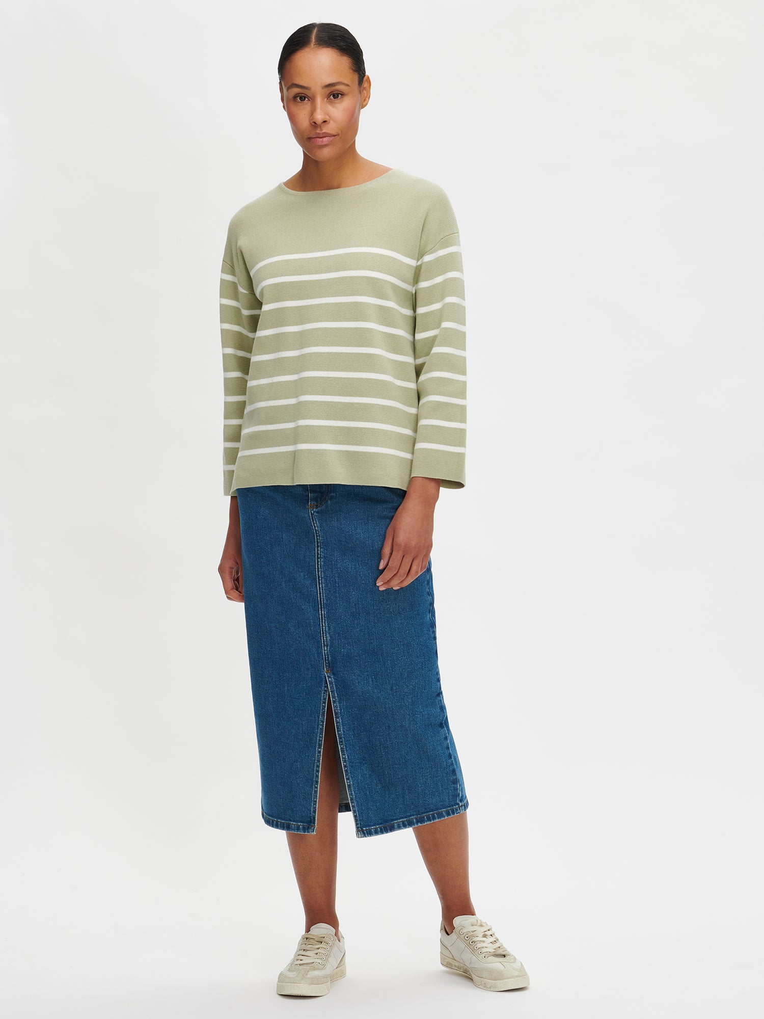 The Milano knit sweater in green for women is a stylish and timeless striped long-sleeved pullover for women. Worn by a model in size S. 