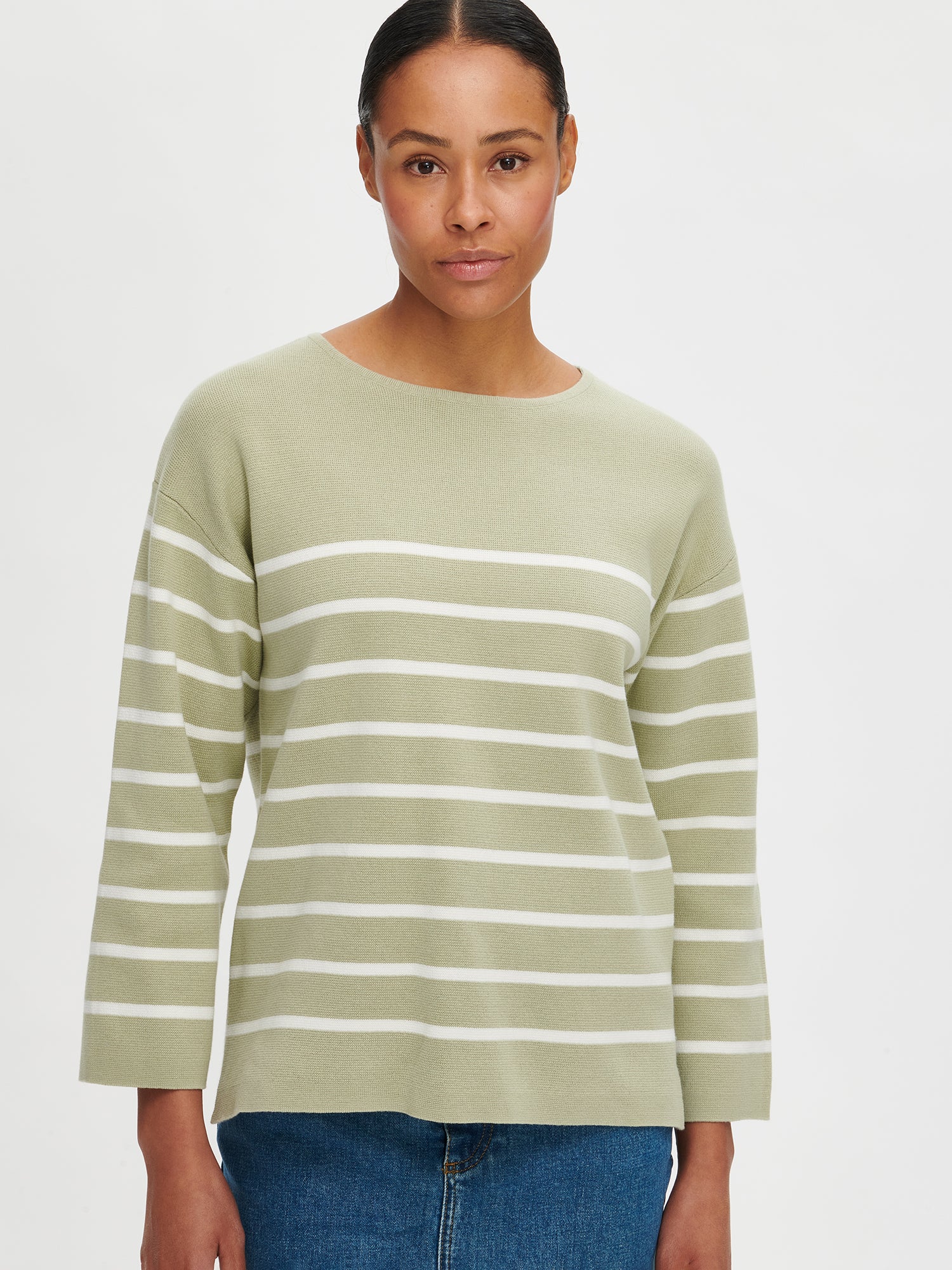 The Milano knit sweater in green for women is a stylish and timeless striped long-sleeved pullover for women. Worn by a model in size S. 