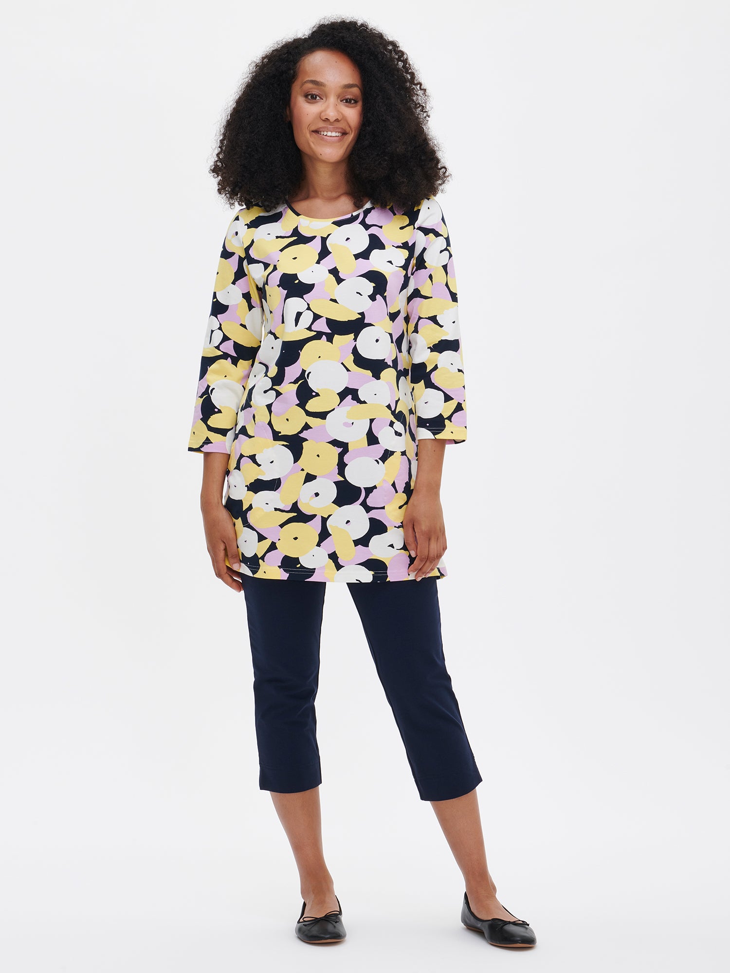 Women's patterned Perenna tunic in yellow. The cozy tunic features a neatly finished round neckline with piping, side pockets, and 3/4-length sleeves. Worn by a model in size S.