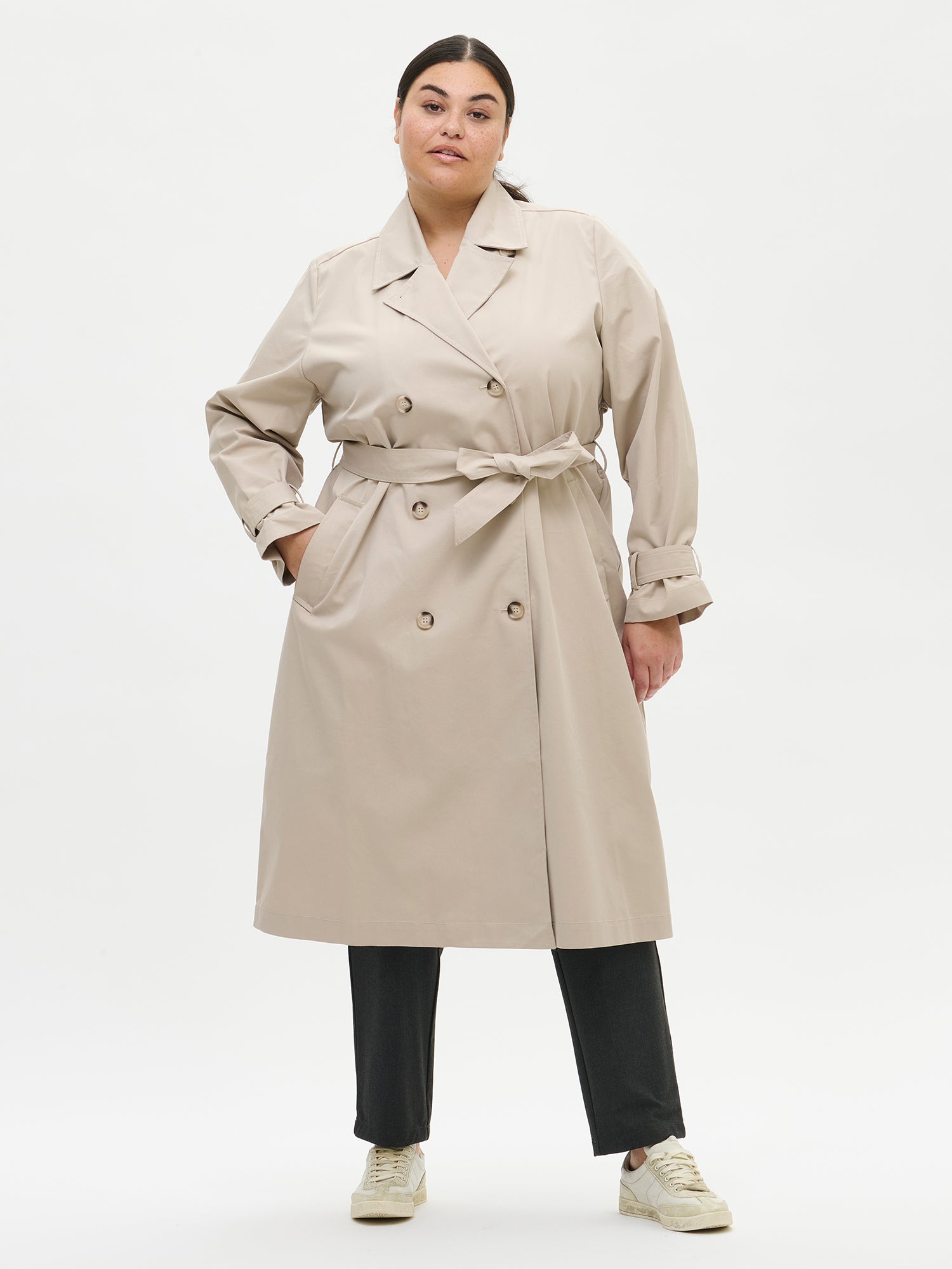 A timeless Beige trench coat on a model with black jeans