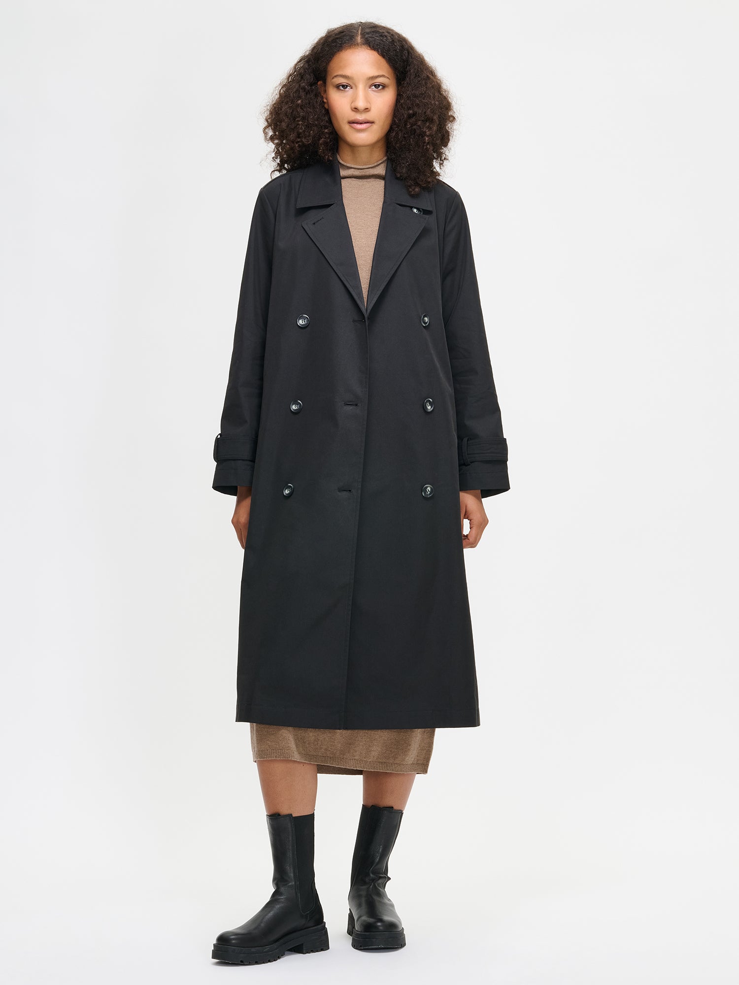 Woman wearing a black coat on a white background