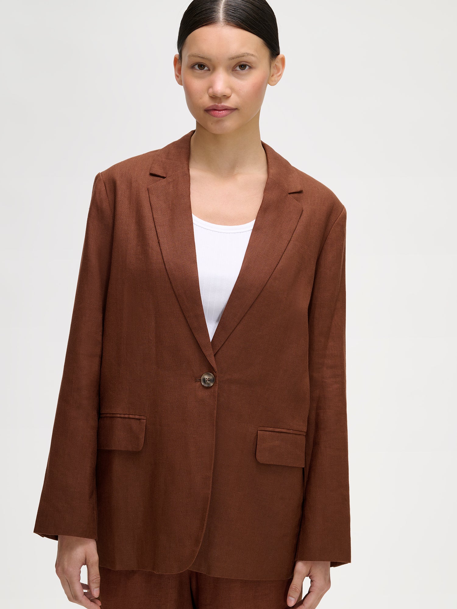 Nanso women's Arles brown linen blazer with brown linen trousers on a model, close-up.