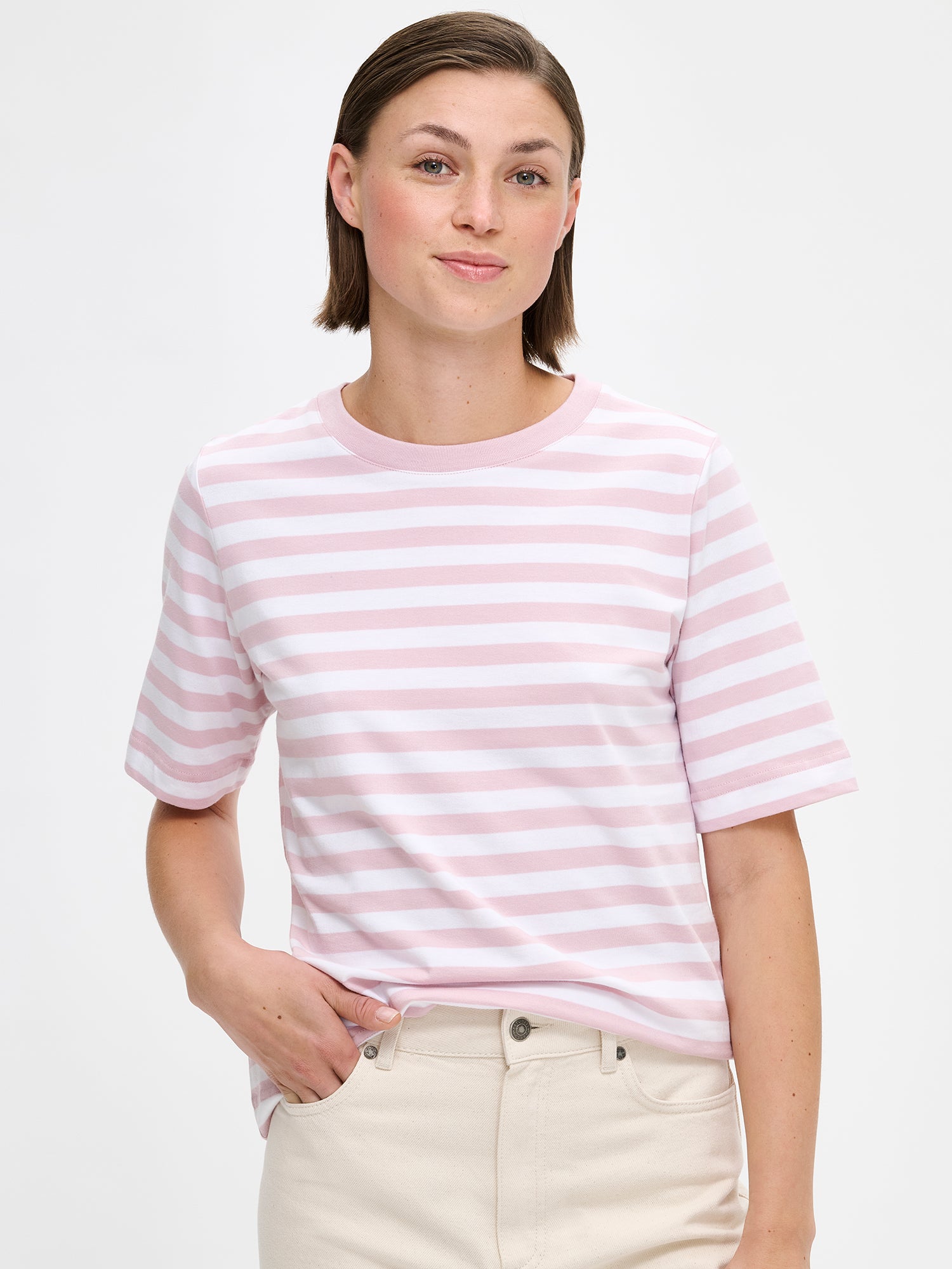 Women's Normi striped T-shirt in Pink with relaxed fit and straightforward silhouette. The material is 100% high-quality organic cotton, which maintains its quality over time. on a model with jeans, close up.