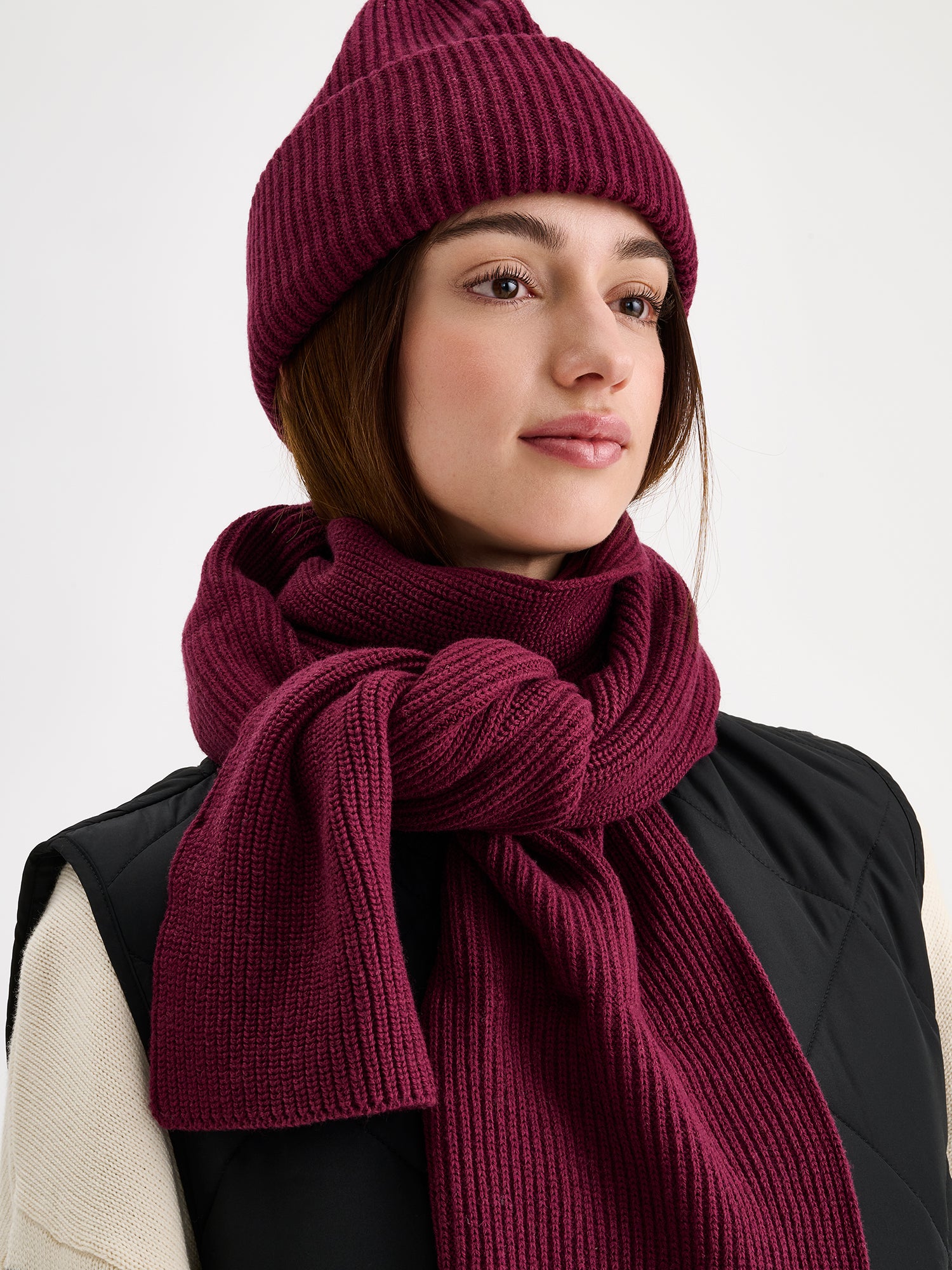 Nanso women's Utu scarf and beanie in a beautiful wine red color on a model.