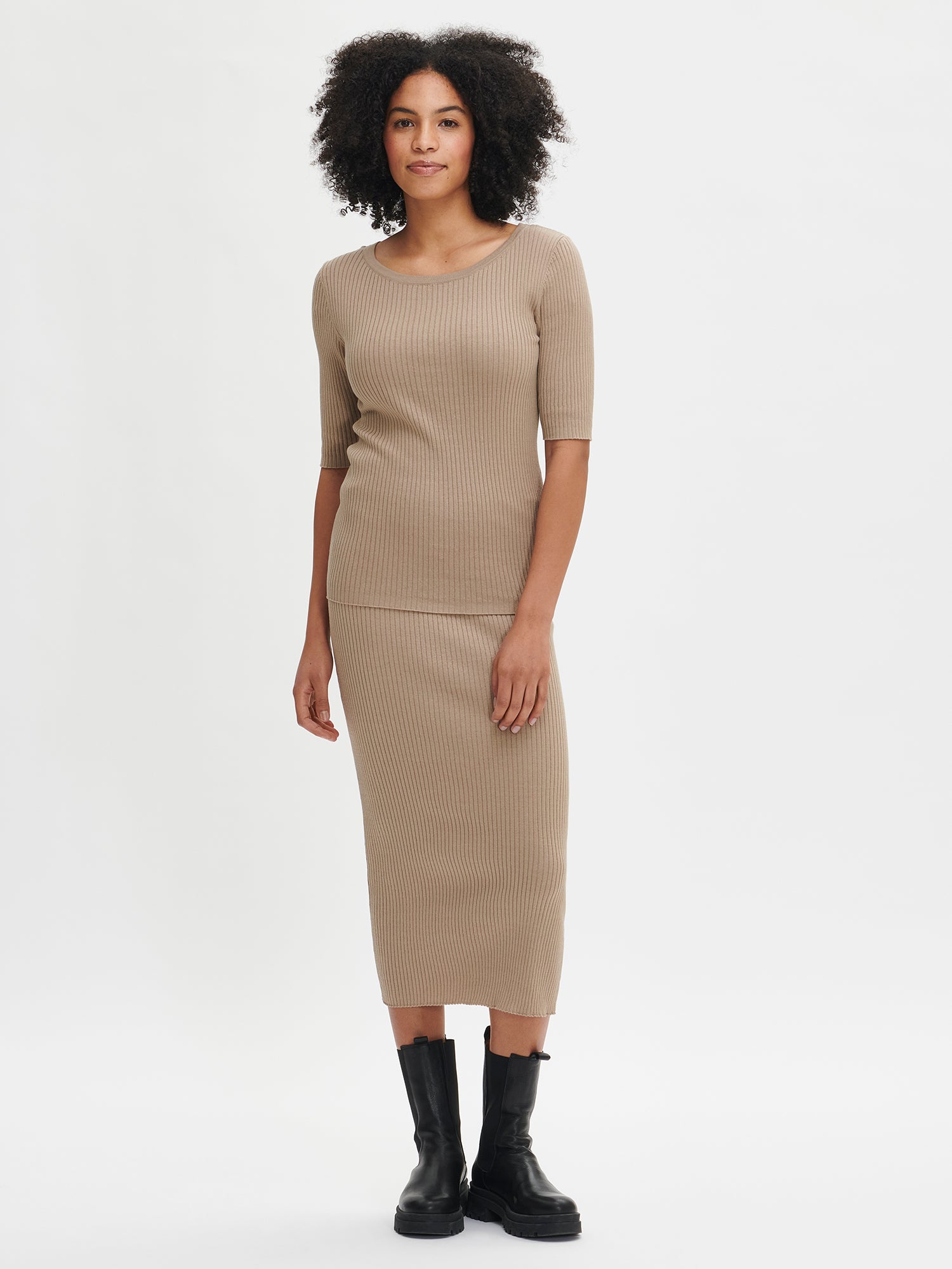 Elegant and lightweight, this women's brown LELA ribbed knit sweater features a boat neckline. Pair it with a knitted skirt or straight pants for a stylish outfit. Worn by a model in size S.