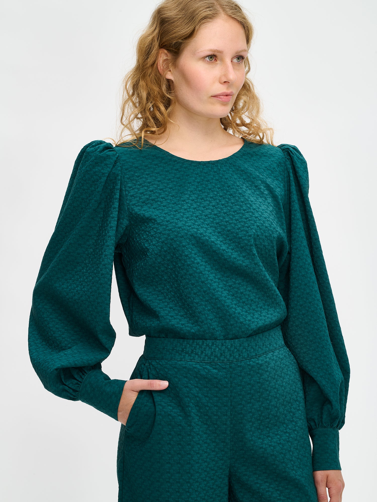 Nanso's stylish women's blouse in dark green features a beautiful textured surface, close-up
