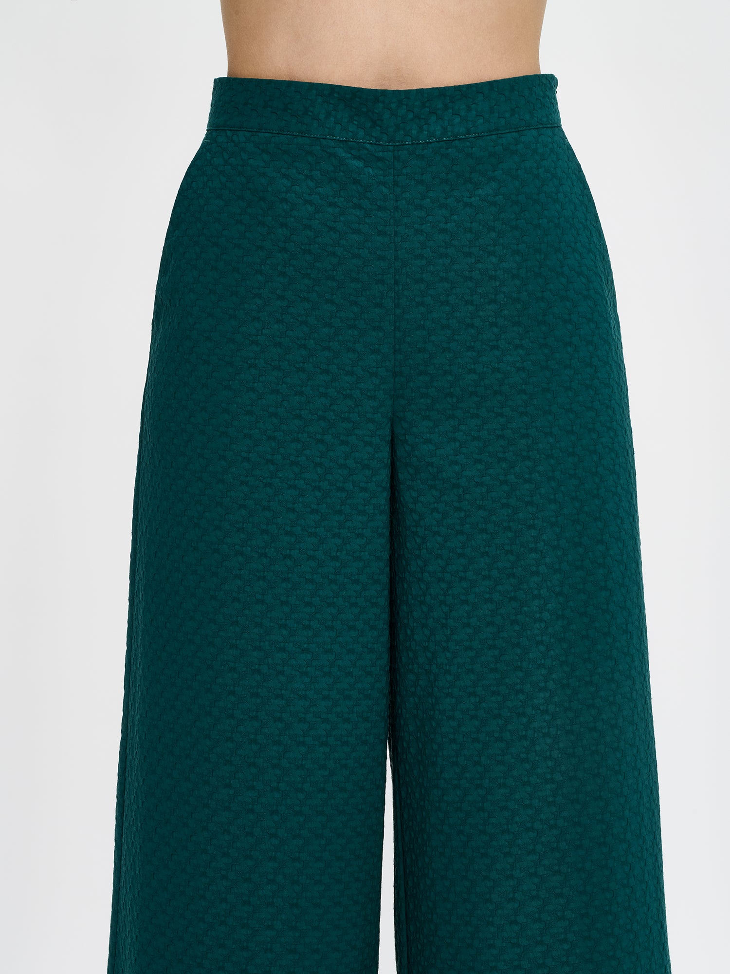Nanso's elegant dark green Reliefi trousers for women feature a stylish textured pattern, perfect for both casual and formal occasions. Image close-up