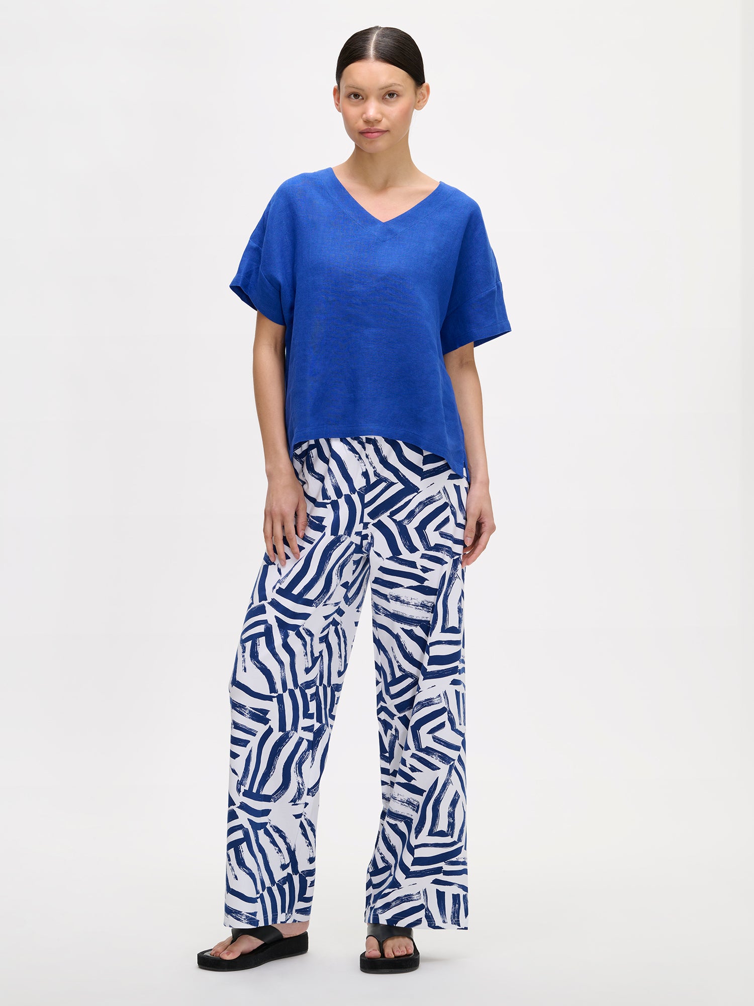 Nanso women's blue solid Sarastus linen shirt for relaxed lounging, on a model with patterned trousers