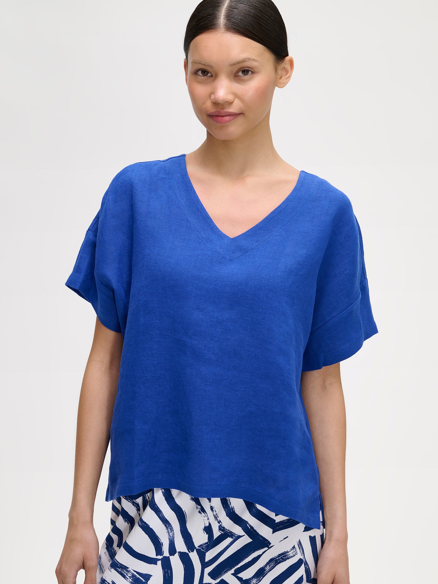 Nanso women's blue solid Sarastus linen shirt for relaxed lounging, on a model with patterned trousers, close-up