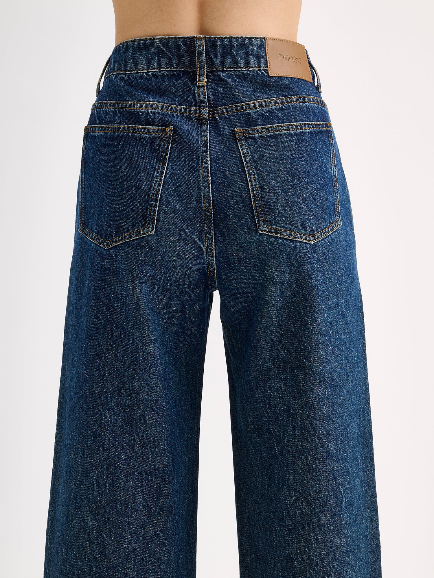 Nanso women's dark blue Cropped Levee jeans on a model pictured from the backside, close-up.