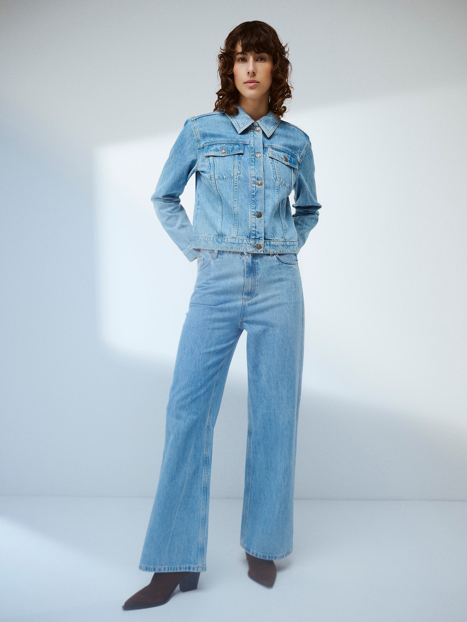 Nanso women’s light blue Levee jeans with a high waist and wide flared legs on a model with a denim jacket 