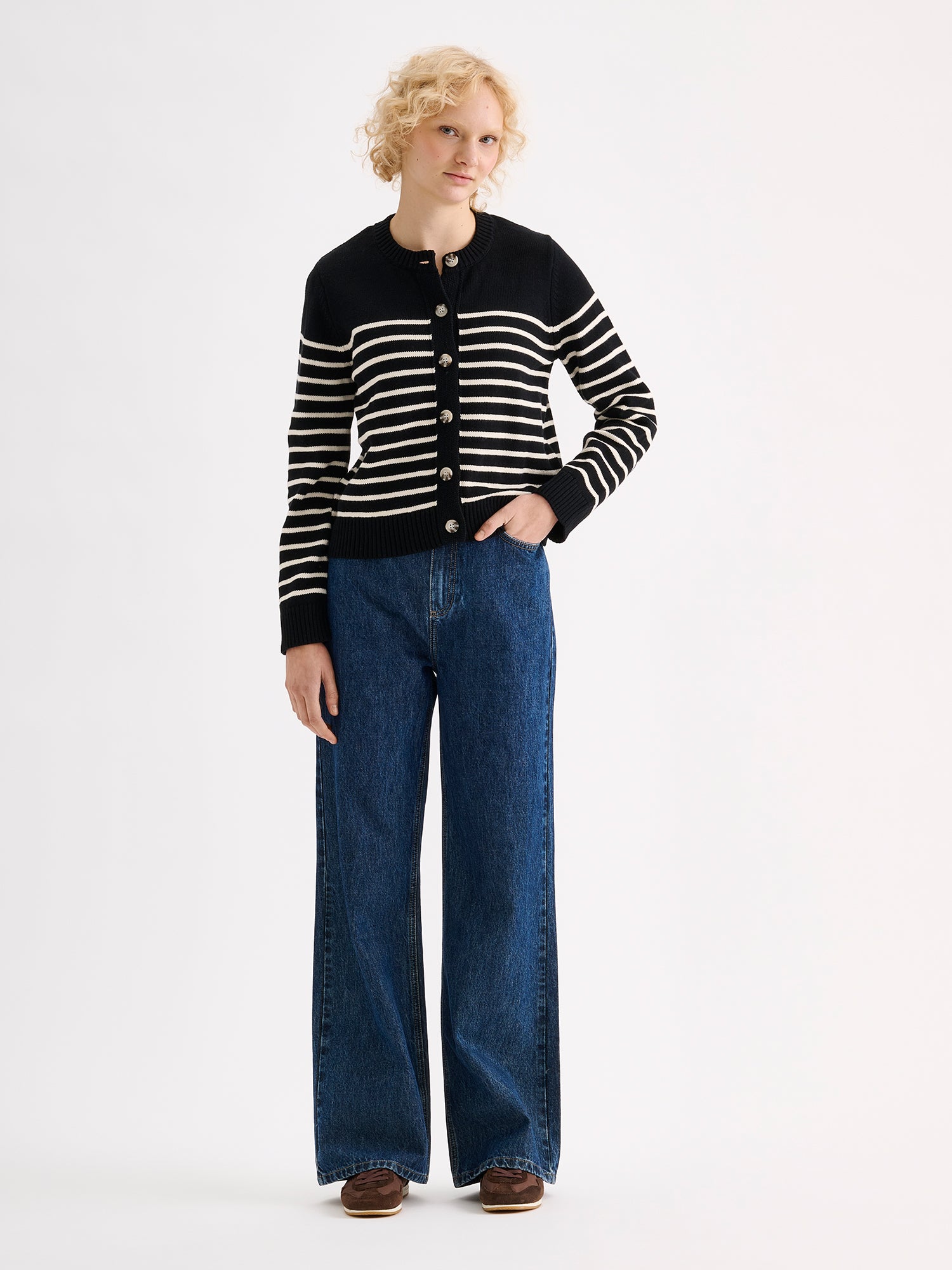Nanso women's straight-cut striped Mira knit cardigan with buttons on a model with blue jeans.