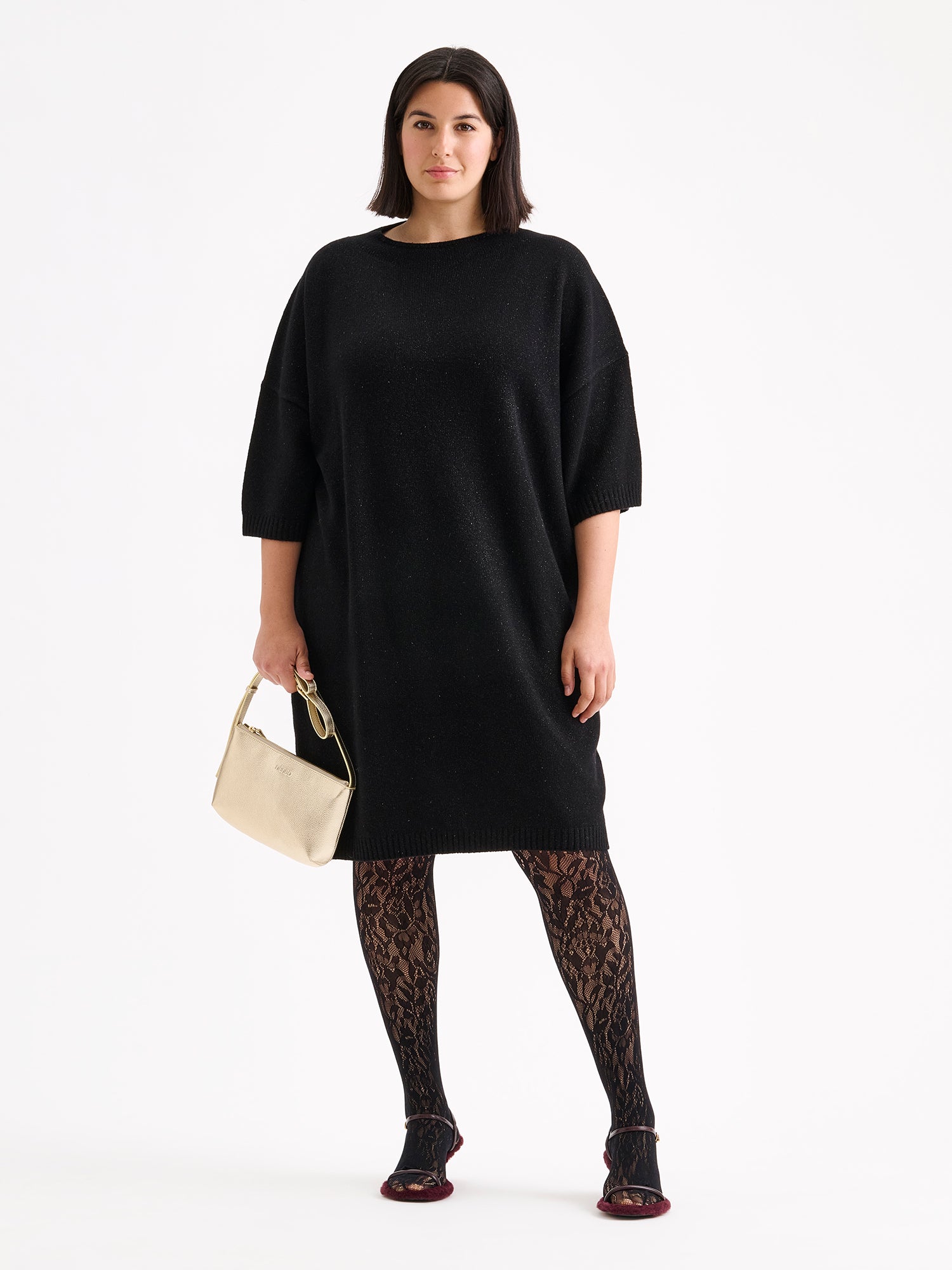 Nanso sleek Naru leather bag in gold, model with a black outfit and the bag.