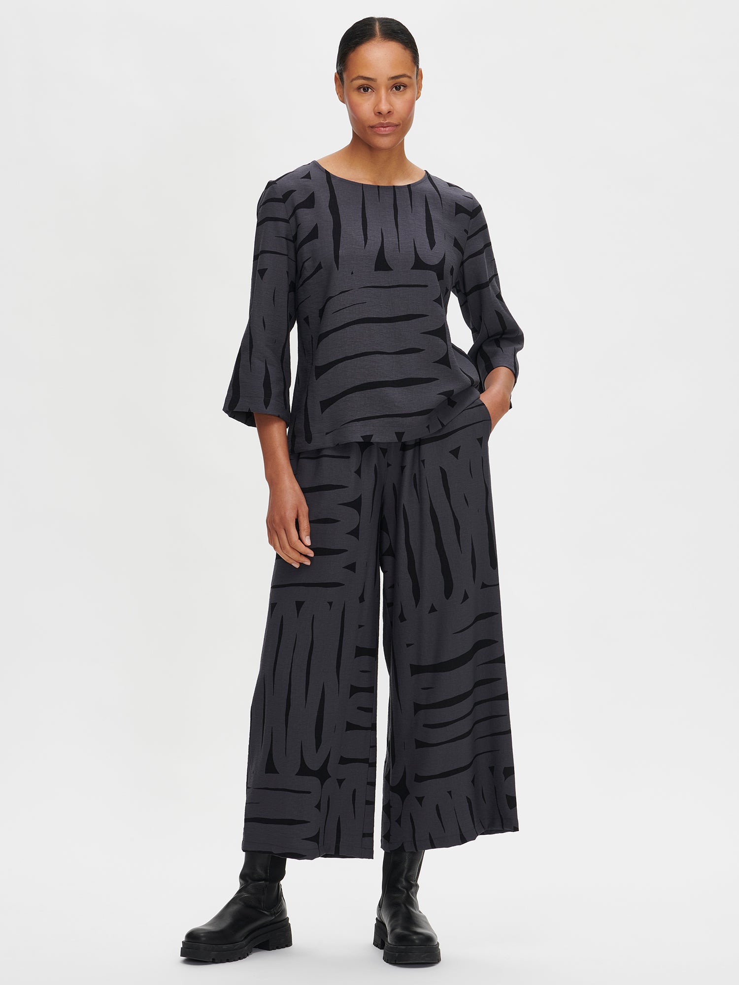 Nanso women's gray Kaiku trousers feature a patterned design, on a model