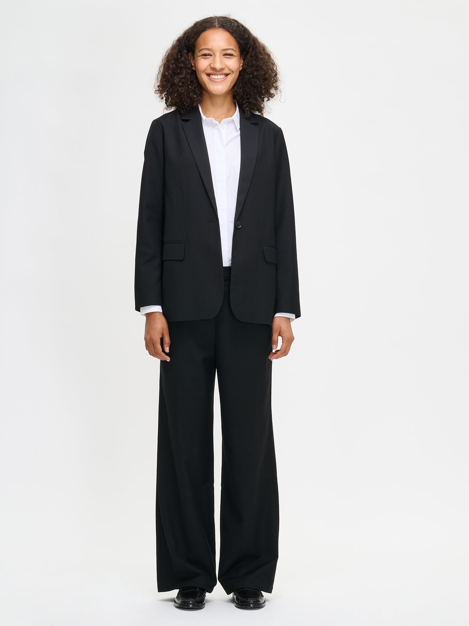 Nanso's black Bea blazer is a timeless and elegant wardrobe essential for women, on a model