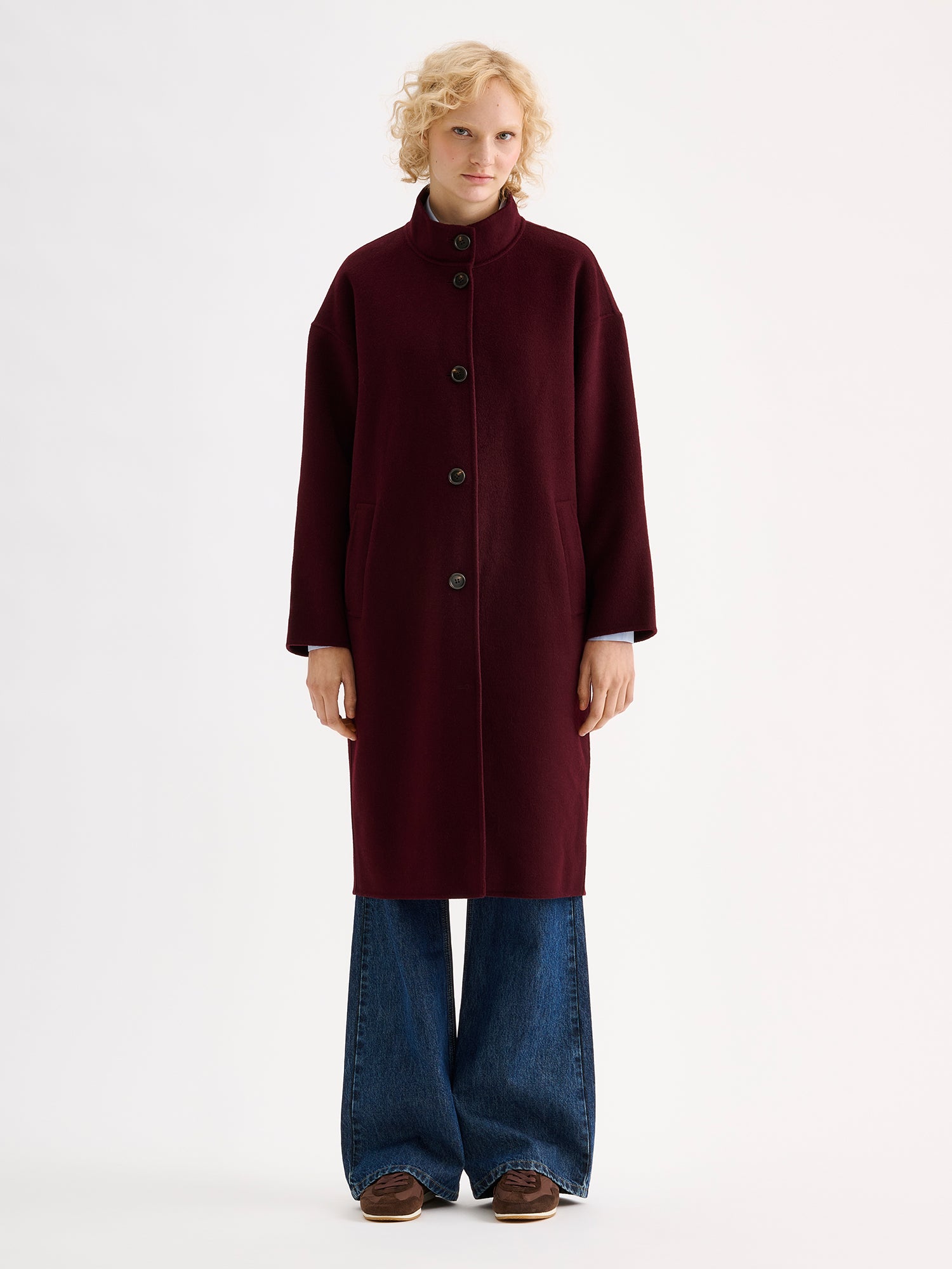 Nanso women's long burgundy Elle wool coat on a blonde model with blue jeans