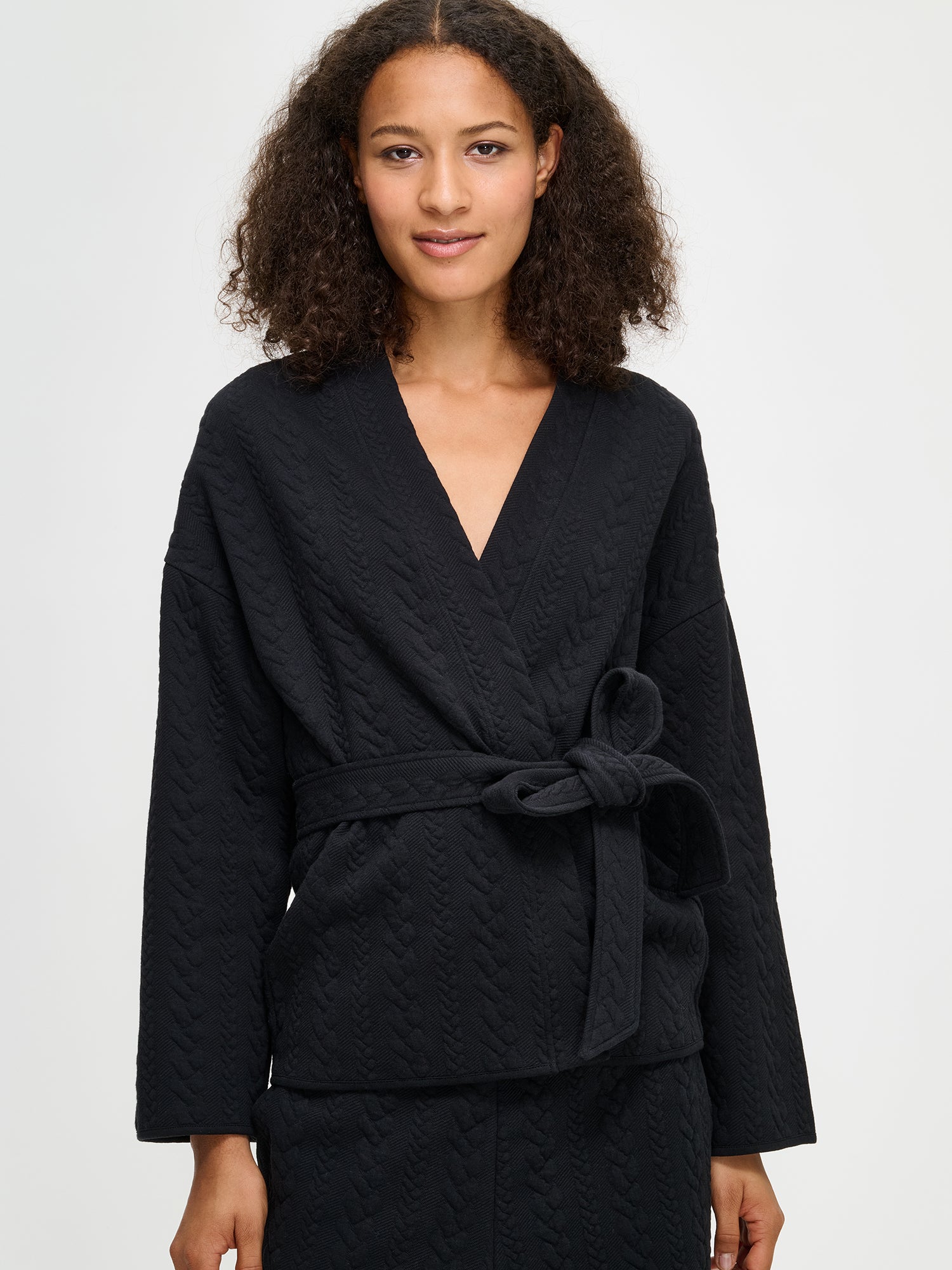 Nanso women's black Letti cardigan features a detachable belt and long sleeves, close-up.