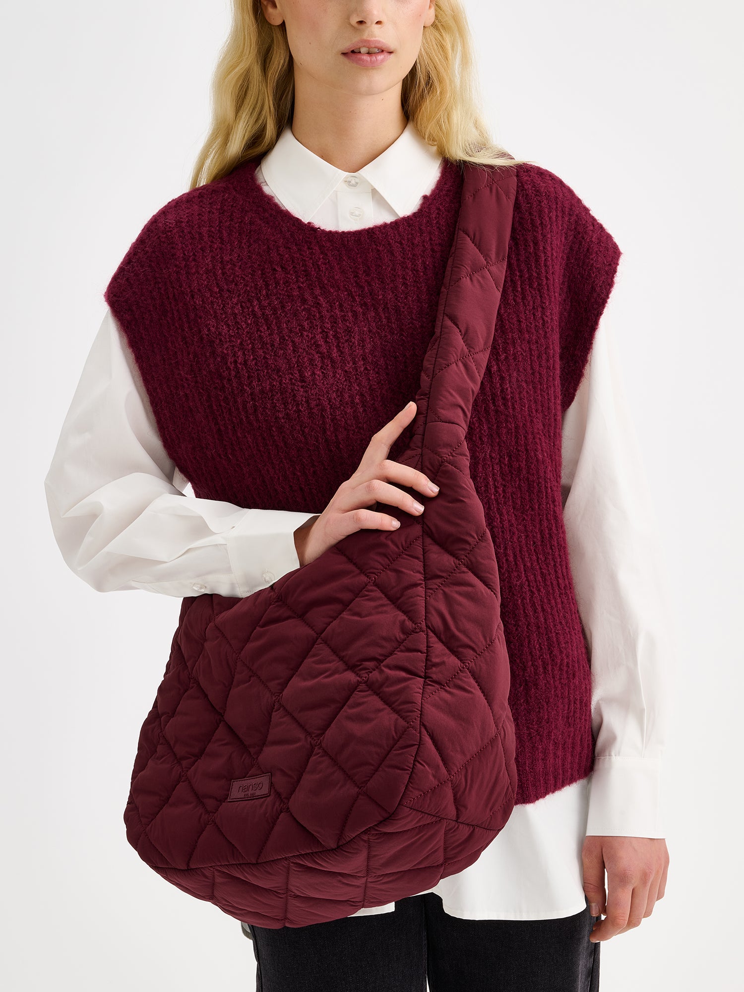 Nanso's winered Maxi Vanu bag features trendy quilted fabric in a spacious design, pictured on a model.