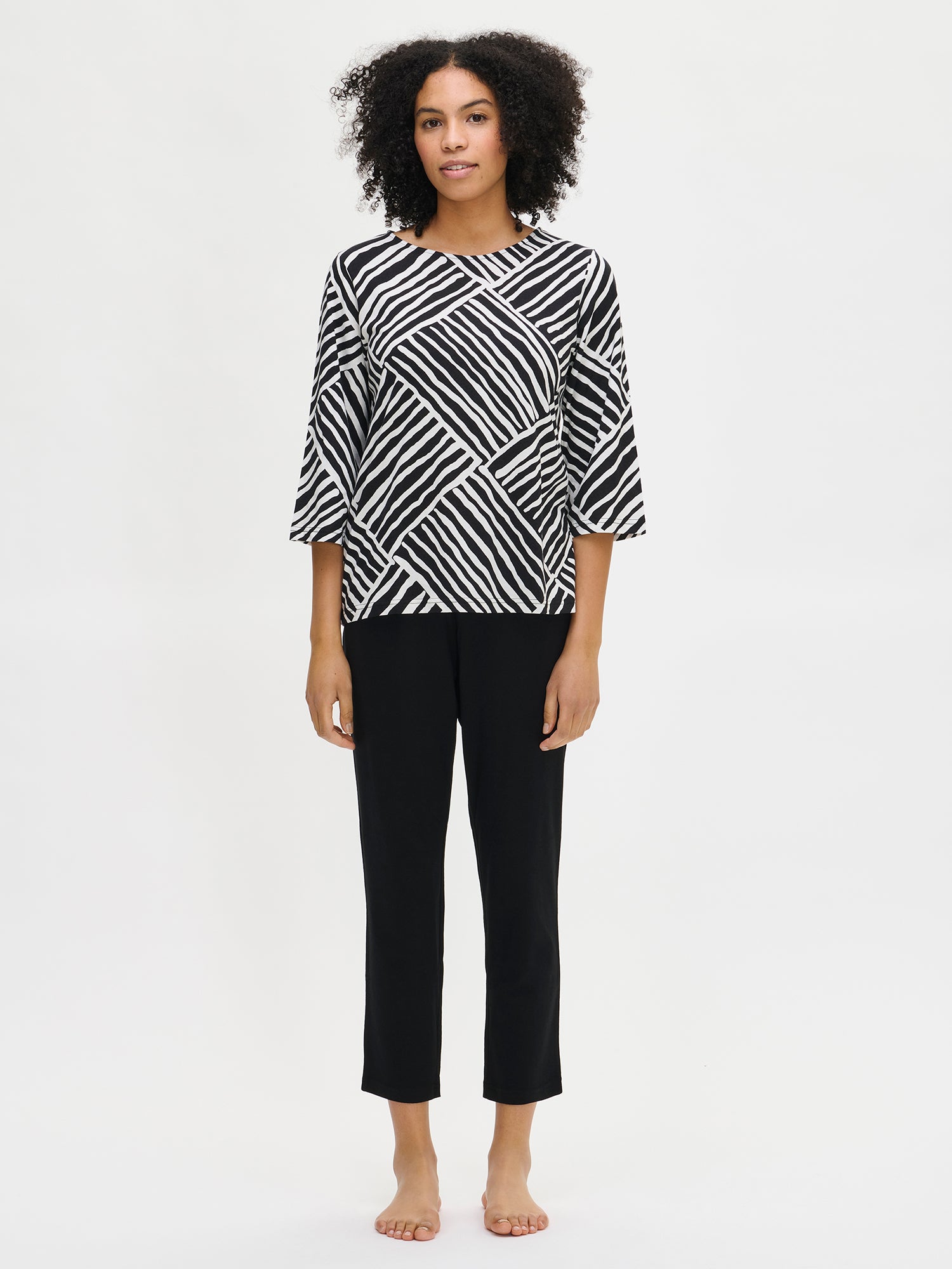 Women’s patterned Kaisli pajama in black and white on a model.