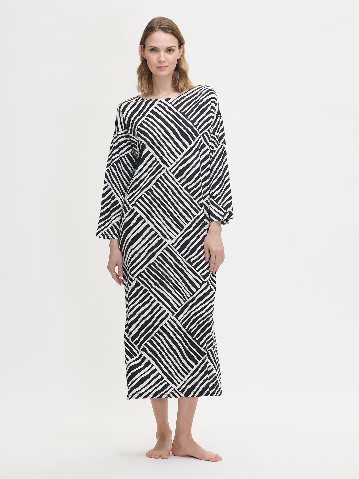 Women’s patterned Kaisli kaftan in black and white on a model.