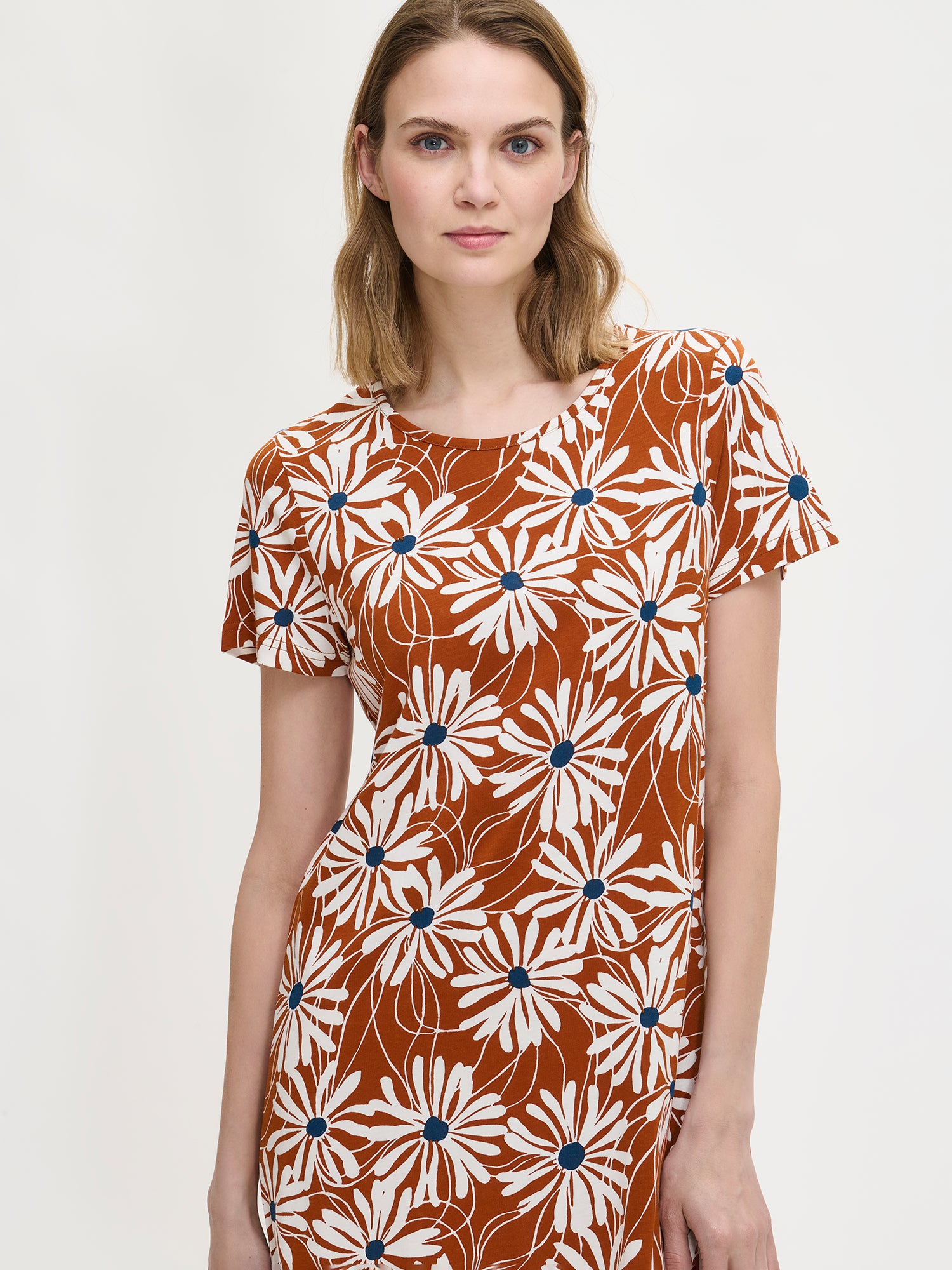 Women’s floral print Anette nightgown with short sleeves and a round neckline in brown on a model in a close-up photo.